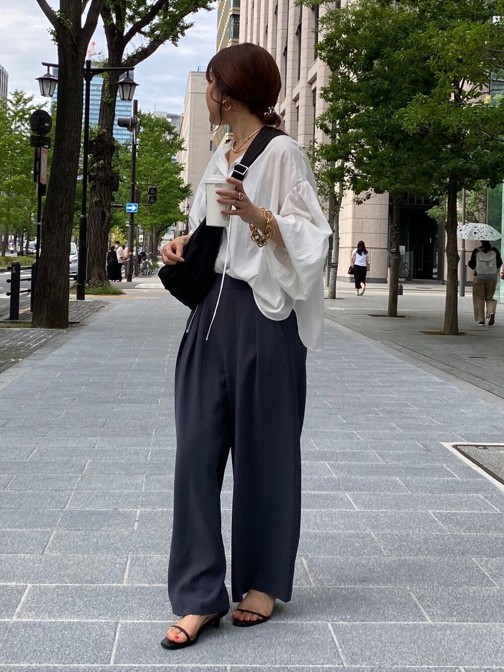 ホワイト系のシャツ/ブラウス、グレー系のスラックス、シルバー系のサンダルを着用したレディースの夏コーディネートの8枚目の写真
