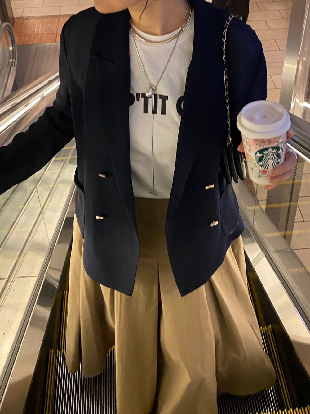 ホワイト系のTシャツ/カットソー、ブルー系のテーラードジャケット、ブラック系のスカートを着用したレディースの春コーディネートの10枚目の写真