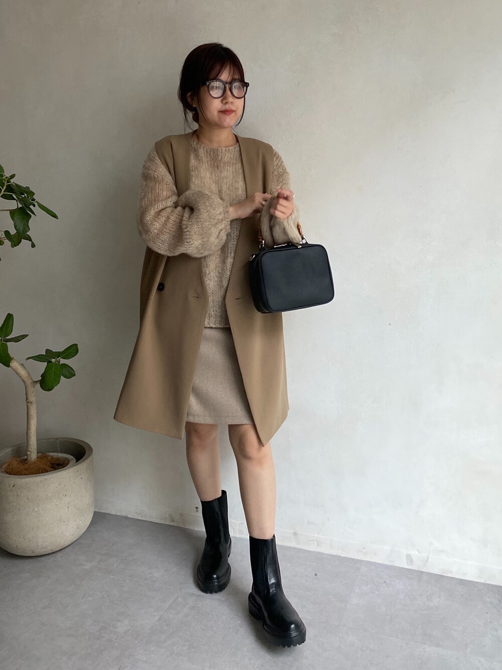 ベージュ系のニット/セーター、イエロー系のベスト、ベージュ系のスカートを着用したレディースの夏コーディネートの5枚目の写真