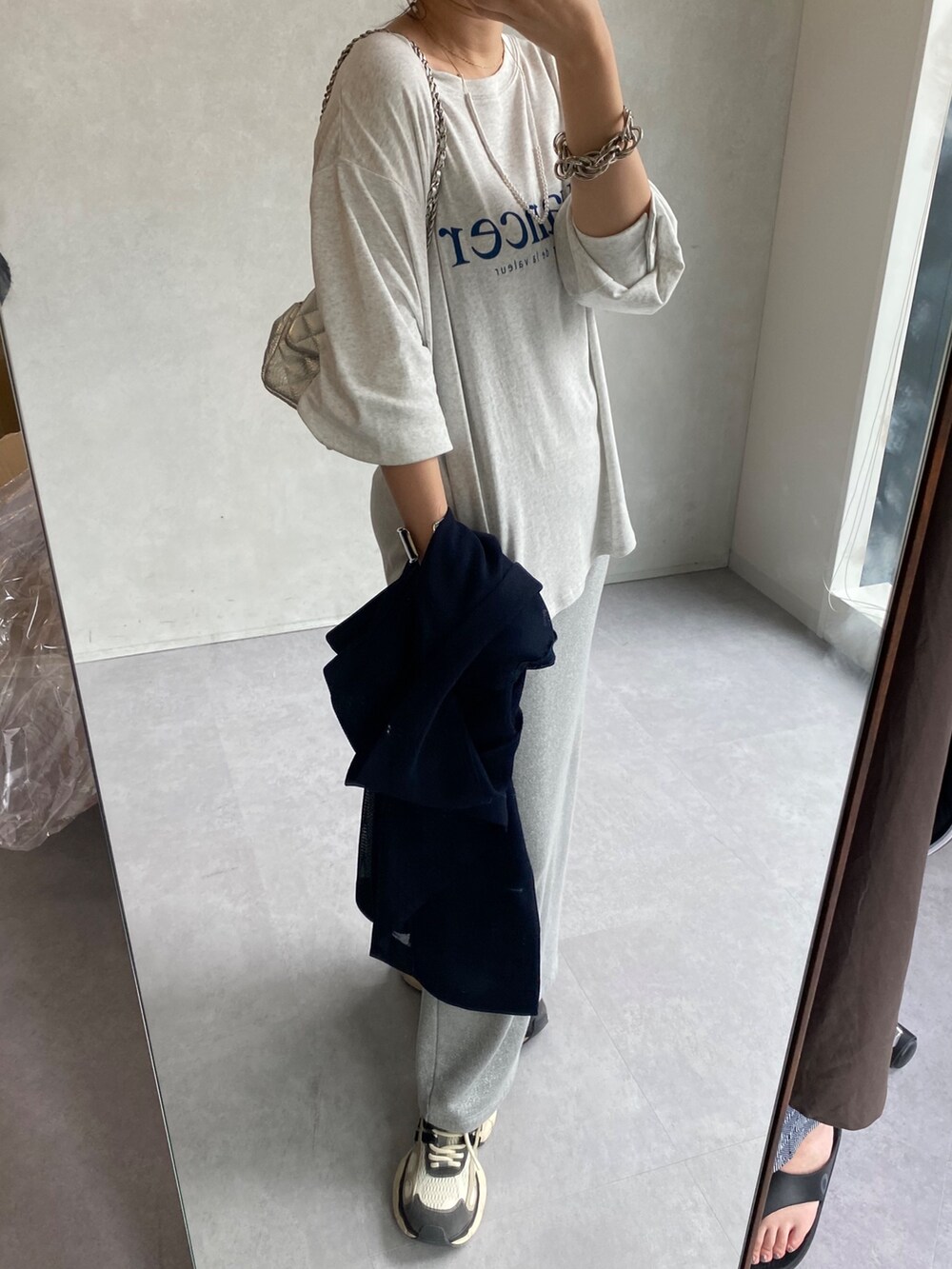 ベージュ系のテーラードジャケット、グレー系のTシャツ/カットソー、シルバー系のスカートを着用したレディースの夏コーディネートの7枚目の写真