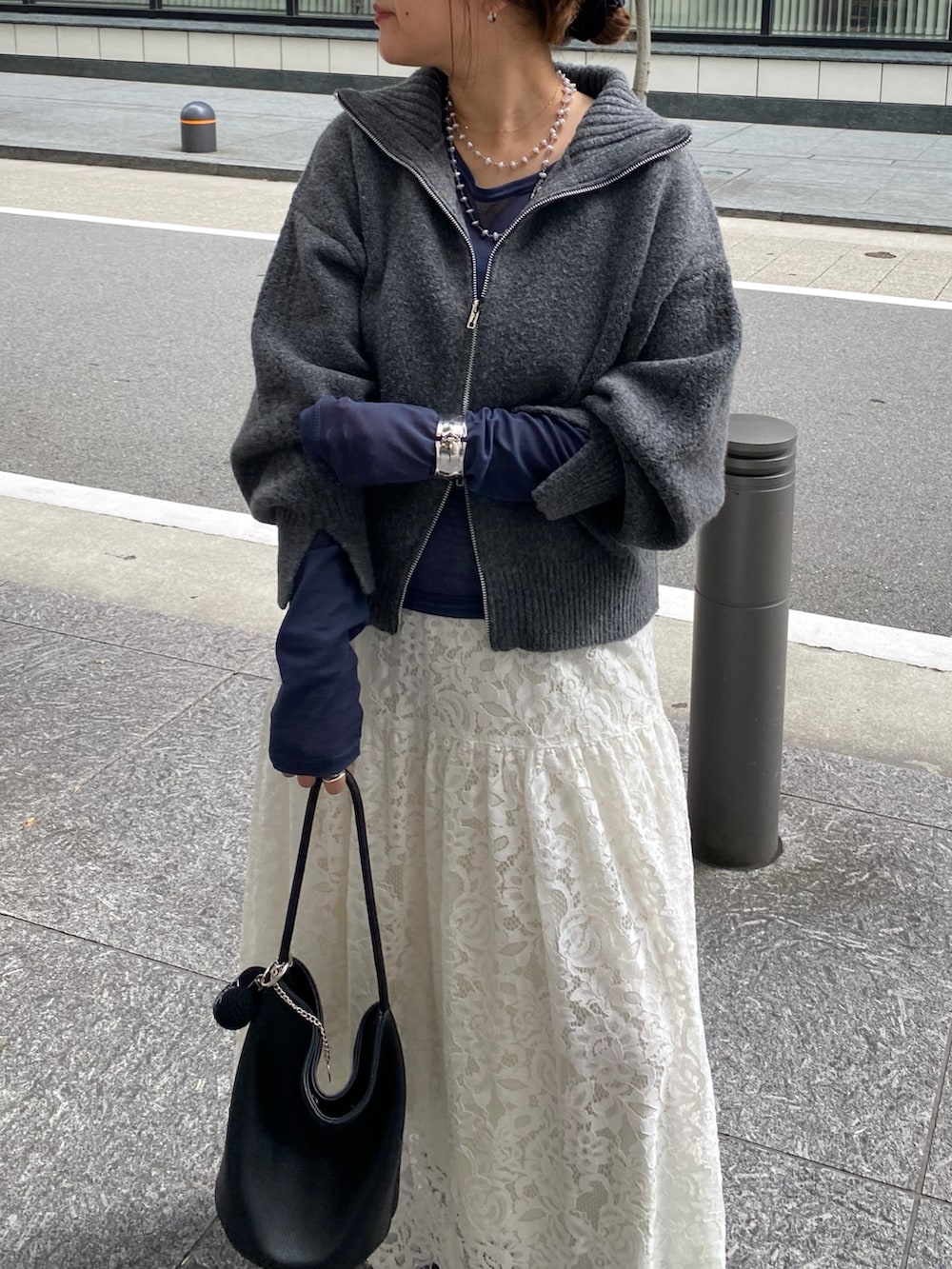 グレー系のカーディガン/ボレロ、ブルー系のTシャツ/カットソー、ホワイト系のスカートを着用したレディースの秋コーディネートの6枚目の写真