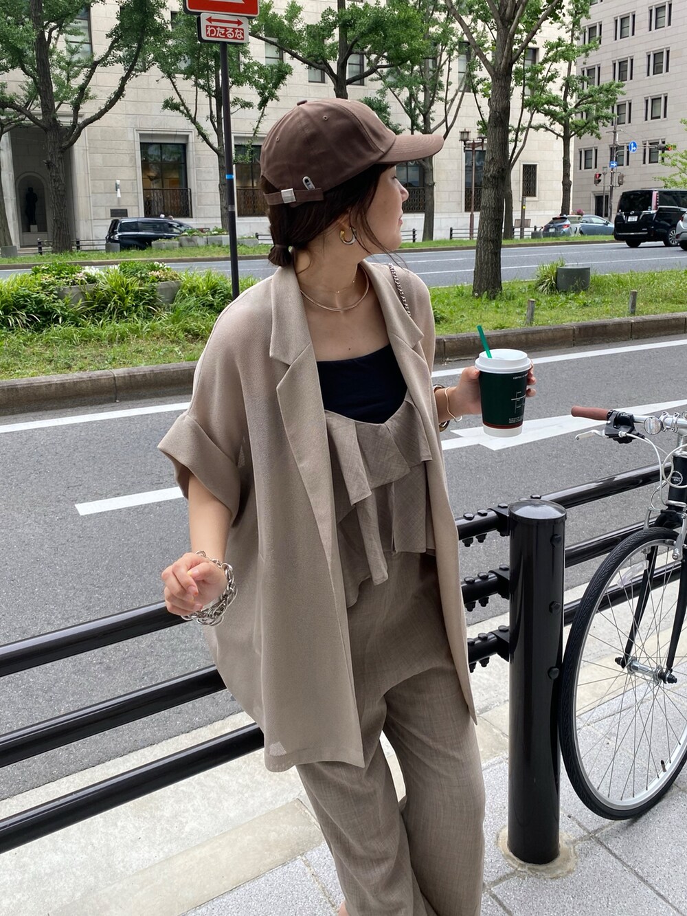 ベージュ系のテーラードジャケット、ベージュ系のつなぎ/オールインワン、ブラウン系のキャップを着用したレディースの夏コーディネートの9枚目の写真