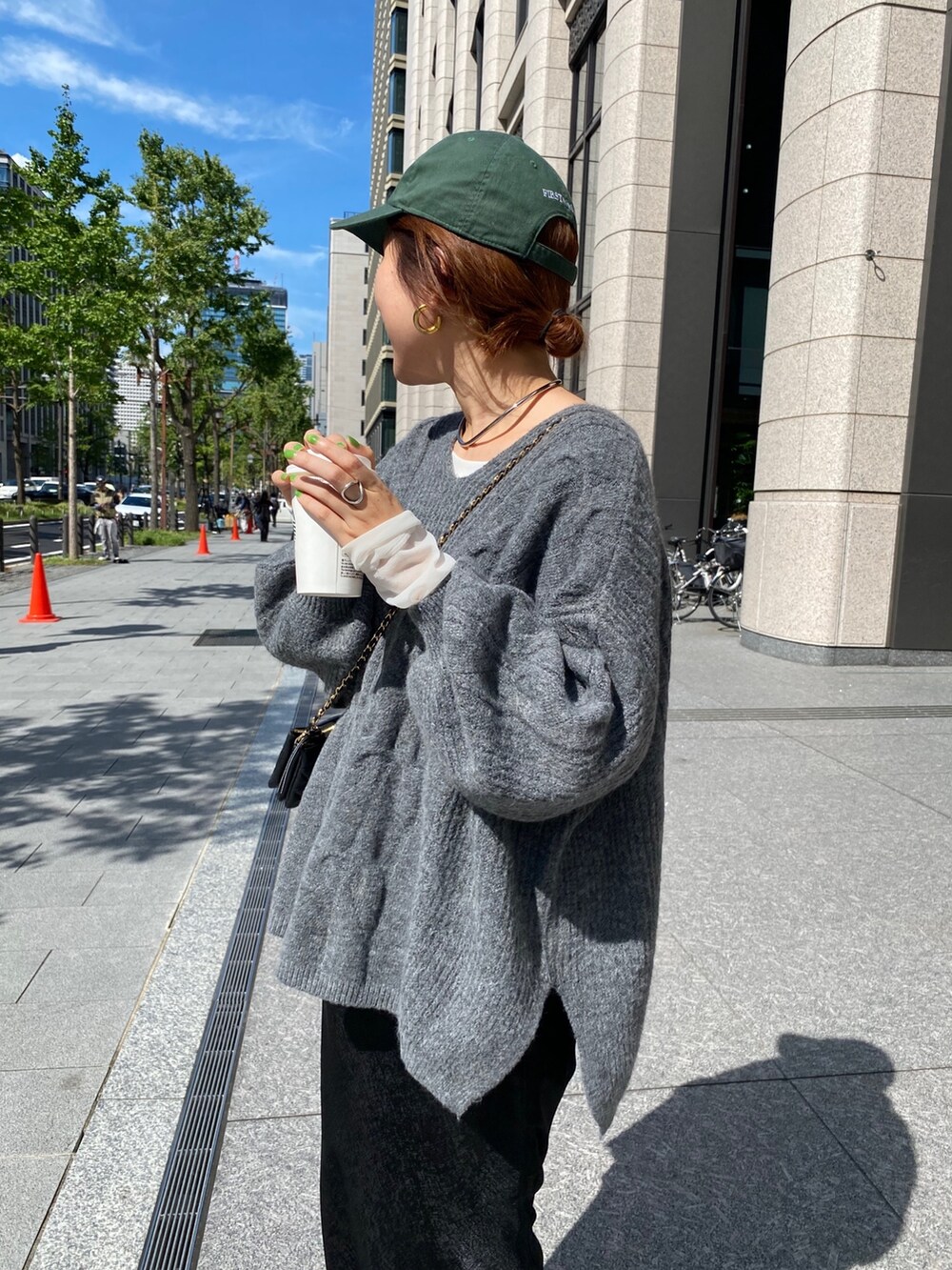 グレー系のニット/セーター、ブラック系のスカートを着用したレディースの秋コーディネートの2枚目の写真