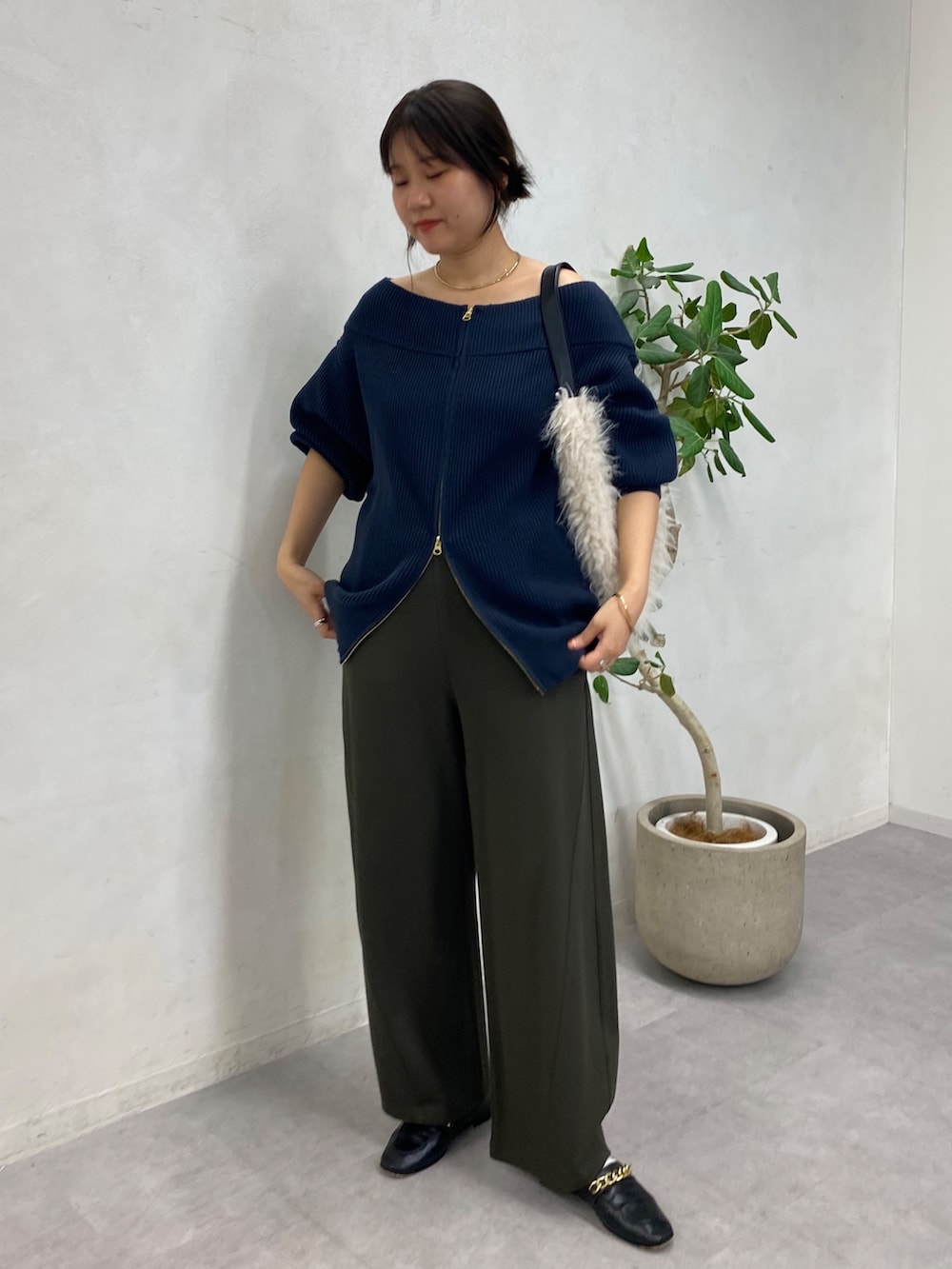 ブルー系のニット/セーター、グリーン系のその他パンツ、ホワイト系のショルダーバッグを着用したレディースの冬コーディネートの3枚目の写真