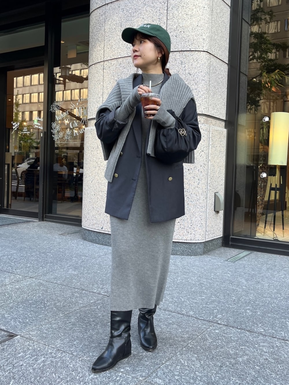 グレー系のテーラードジャケット、ベージュ系のワンピース、ブラック系のブーツを着用したレディースの冬コーディネートの2枚目の写真