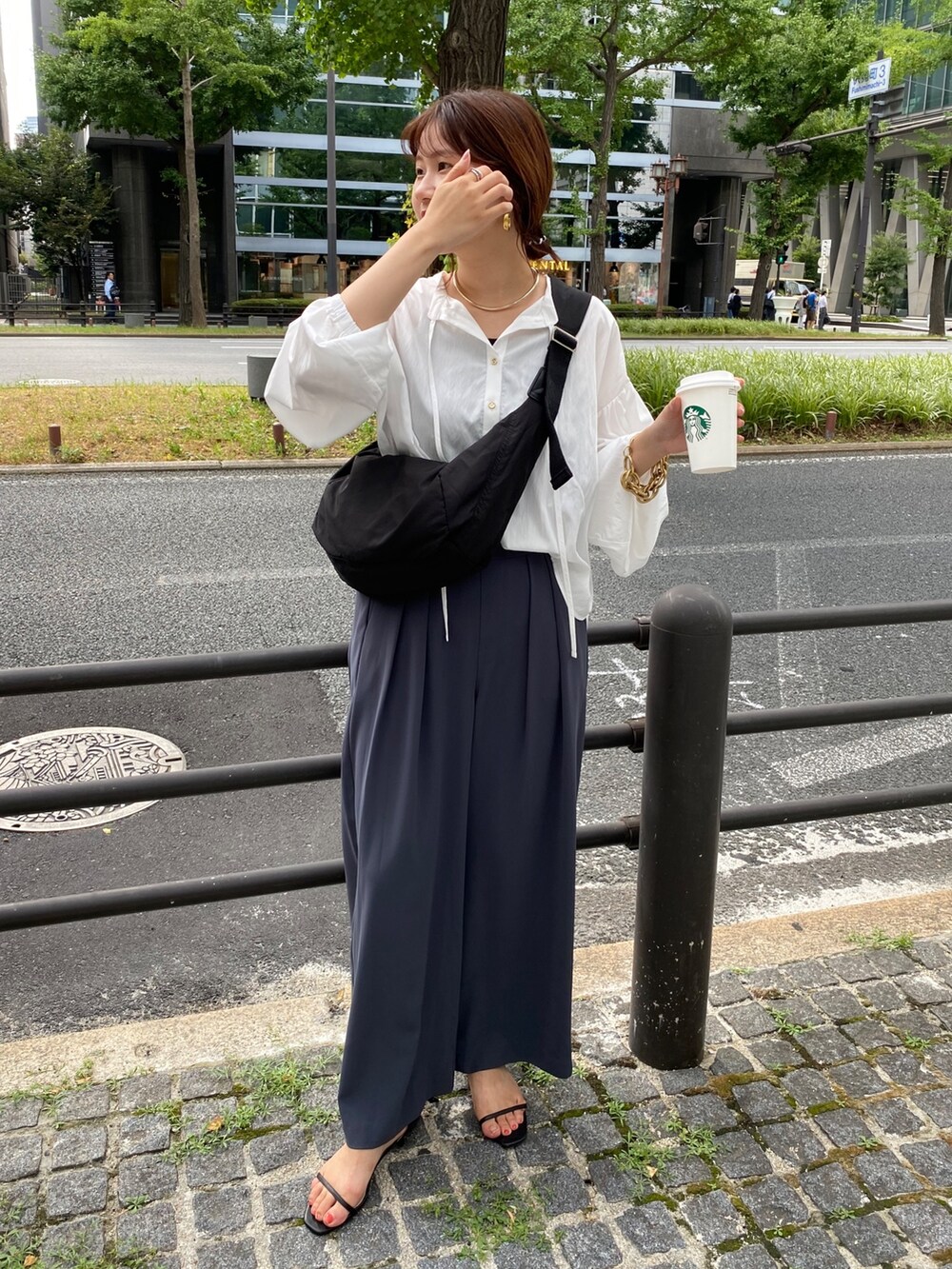 ホワイト系のシャツ/ブラウス、グレー系のスラックス、シルバー系のサンダルを着用したレディースの夏コーディネートの9枚目の写真