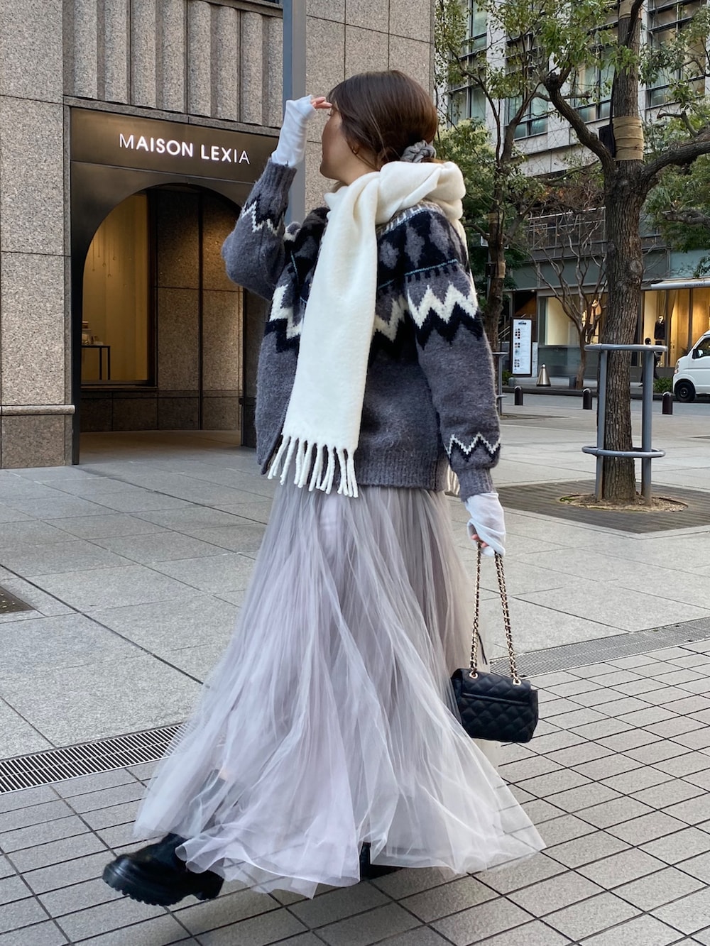 グレー系のカーディガン/ボレロ、ブルー系のTシャツ/カットソー、グレー系のスカートを着用したレディースの冬コーディネートの2枚目の写真