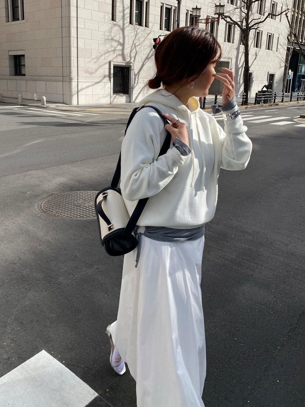 ホワイト系のスカート、ブラウン系のショルダーバッグ、グレー系のTシャツ/カットソーを着用したレディースの春コーディネートの8枚目の写真