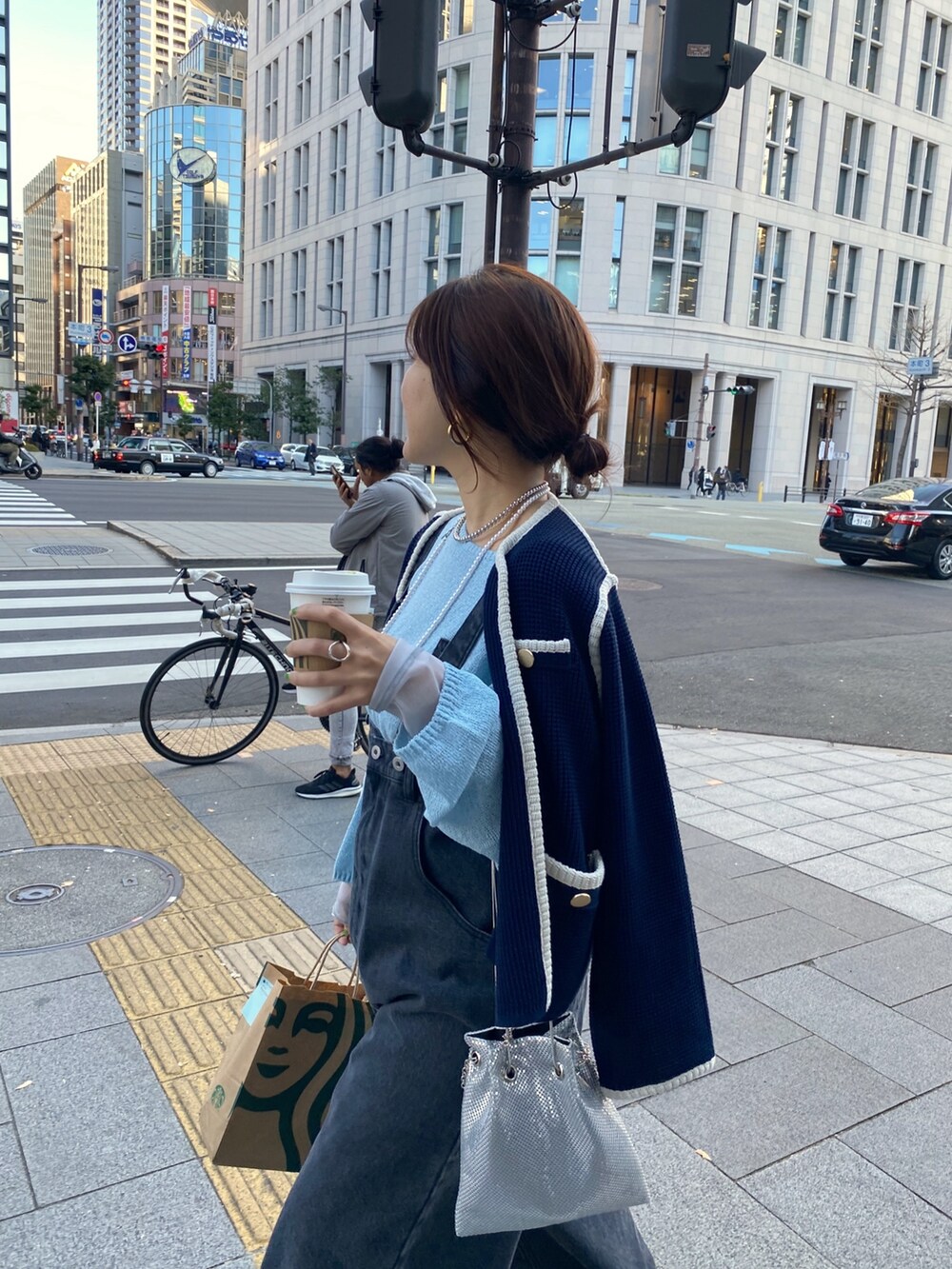 ブルー系のノーカラージャケット、ブラック系のサロペット/オーバーオール、ゴールド系のショルダーバッグを着用したレディースの冬コーディネートの9枚目の写真