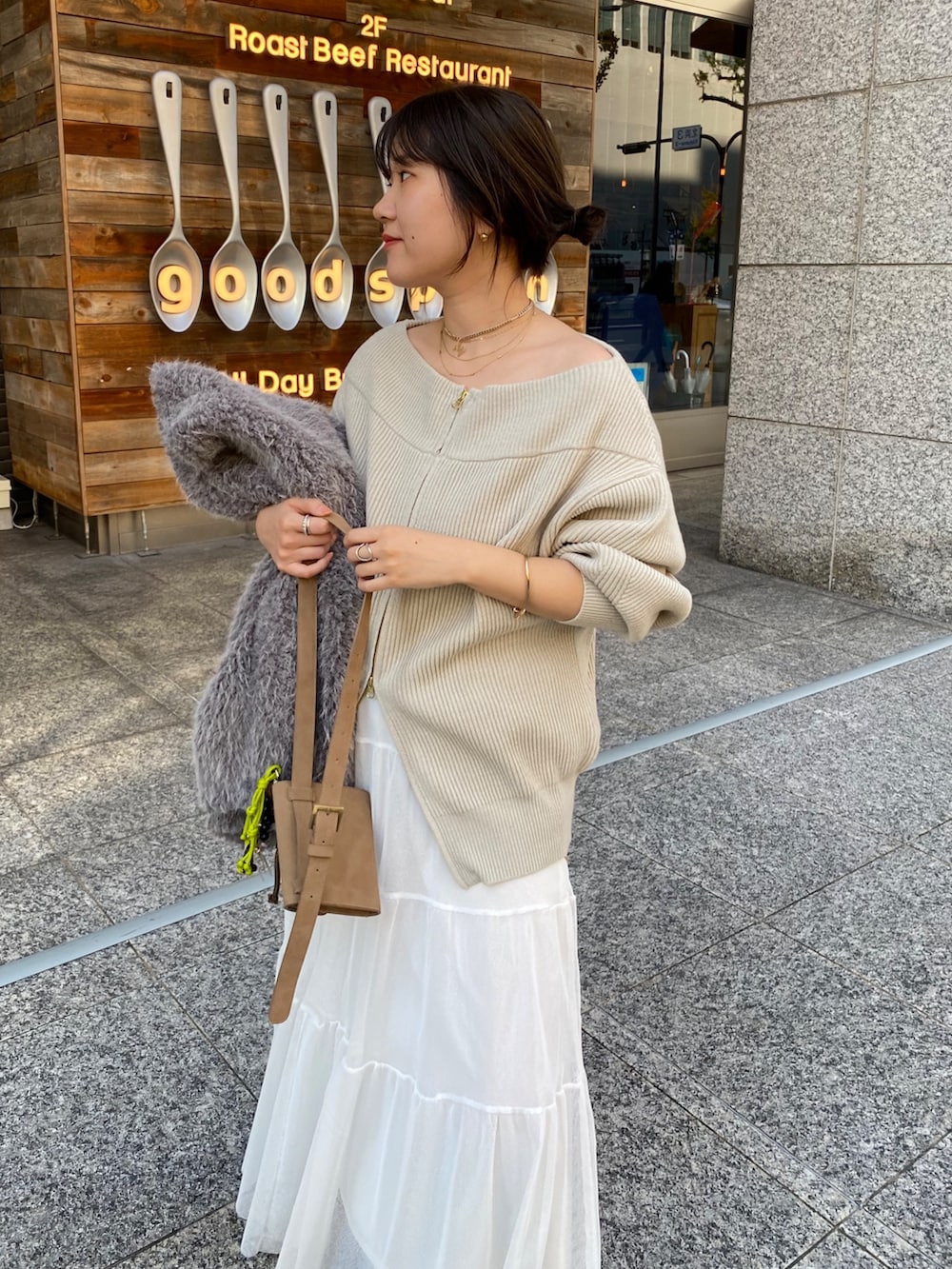 ベージュ系のニット/セーター、ホワイト系のスカート、グレー系のその他アウターを着用したレディースの冬コーディネートの10枚目の写真