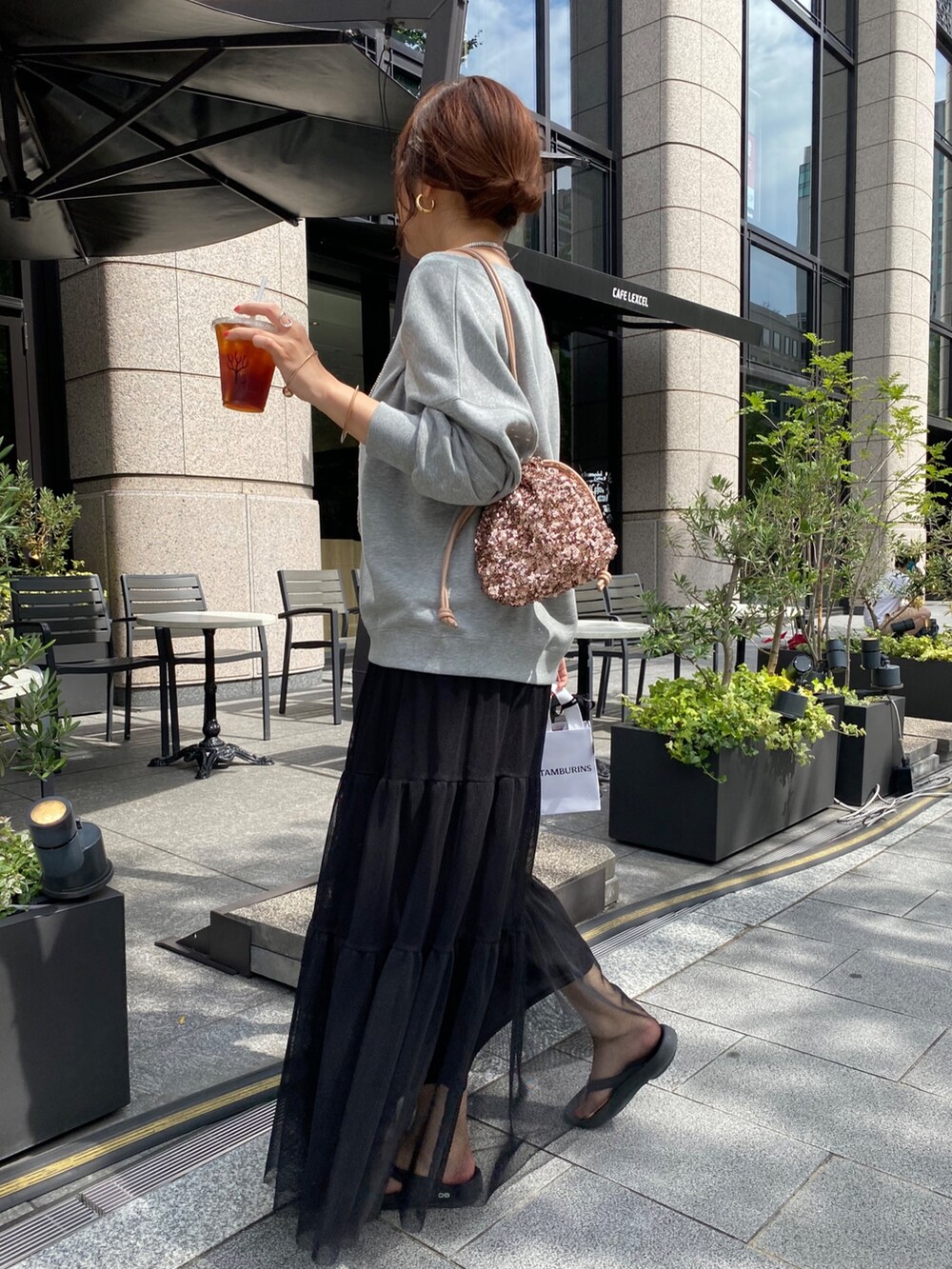 グレー系のスウェット、ブラック系のスカート、ピンク系のハンドバッグを着用したレディースの秋コーディネートの7枚目の写真