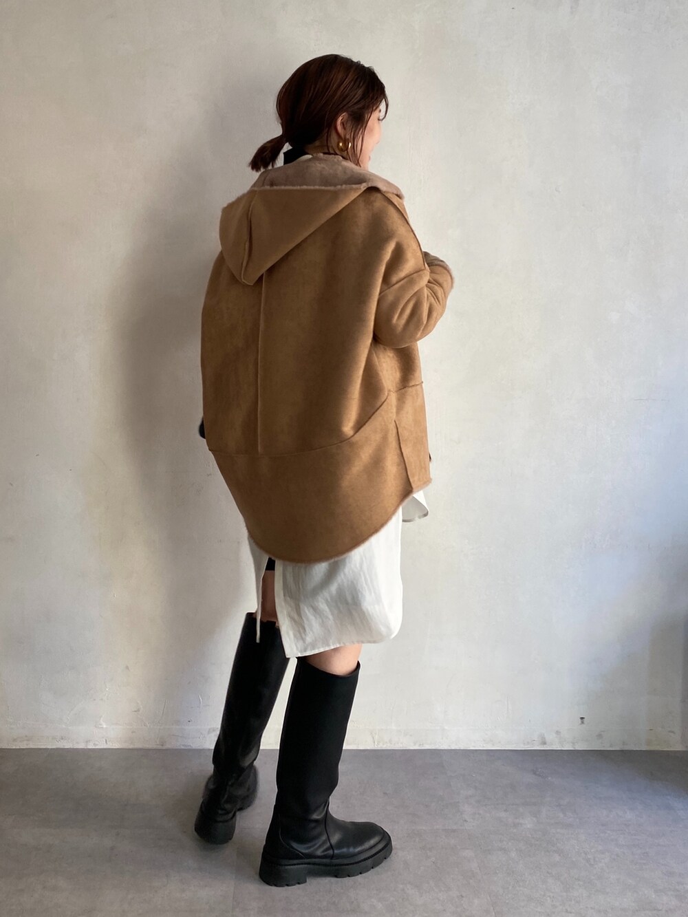 イエロー系のその他アウター、ホワイト系のニット/セーター、ブラック系のその他パンツを着用したレディースの冬コーディネートの4枚目の写真