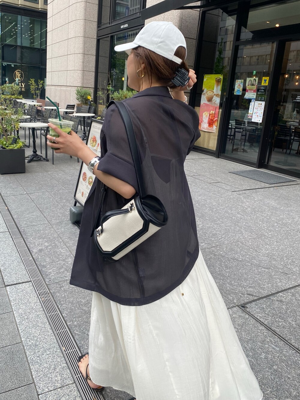 グレー系のテーラードジャケット、ホワイト系のワンピース、ホワイト系のキャップを着用したレディースの夏コーディネートの3枚目の写真