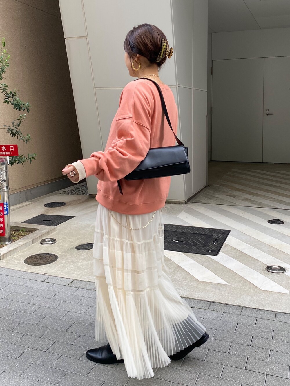 ブラウン系のその他アウター、オレンジ系のスウェット、ホワイト系のスカートを着用したレディースの冬コーディネートの2枚目の写真