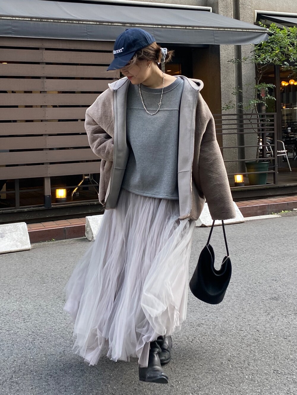 グレー系のムートンコート、グレー系のTシャツ/カットソー、グレー系のスカートを着用したレディースの冬コーディネートの4枚目の写真