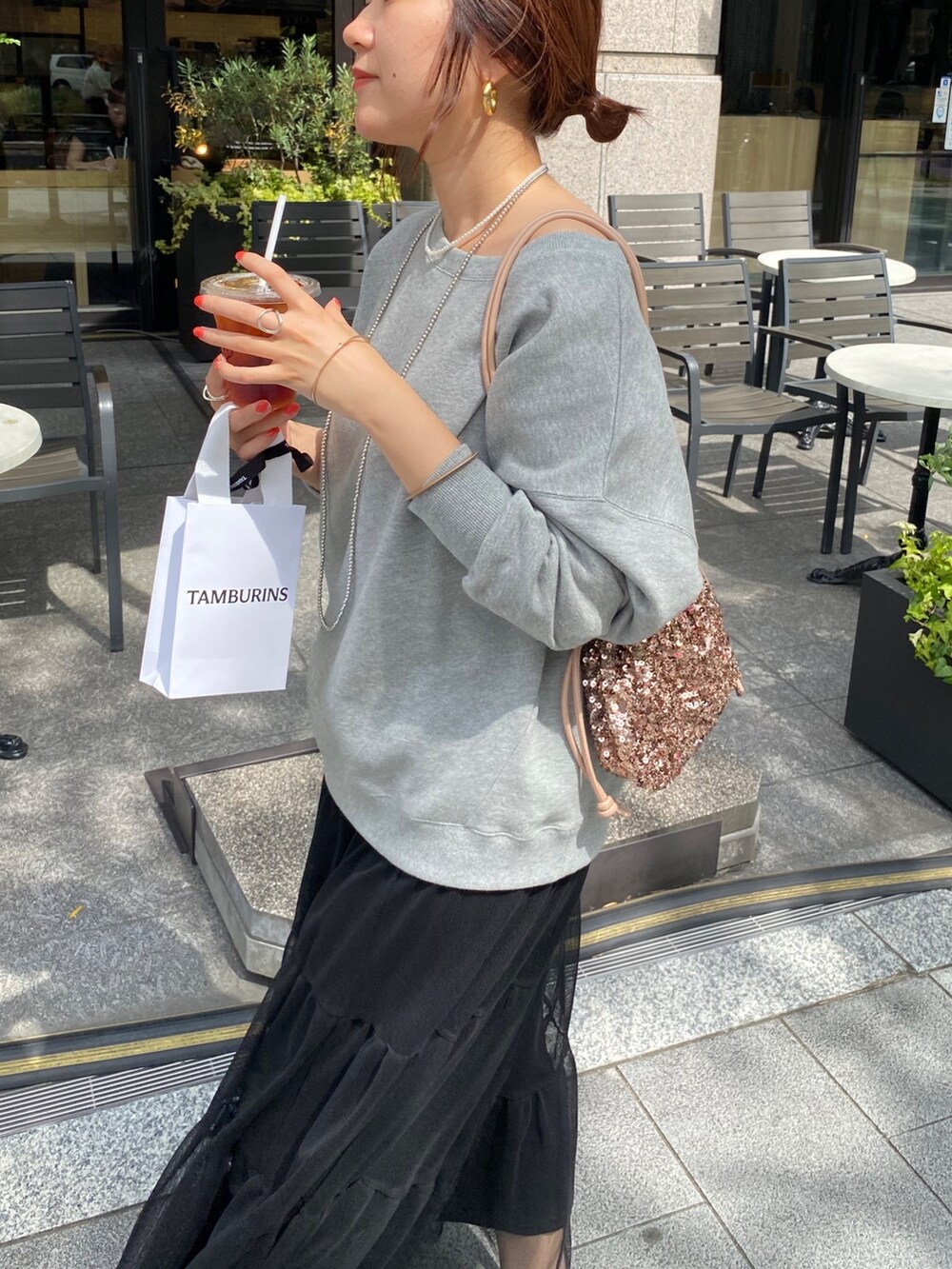 グレー系のスウェット、ブラック系のスカート、ピンク系のハンドバッグを着用したレディースの秋コーディネートの4枚目の写真