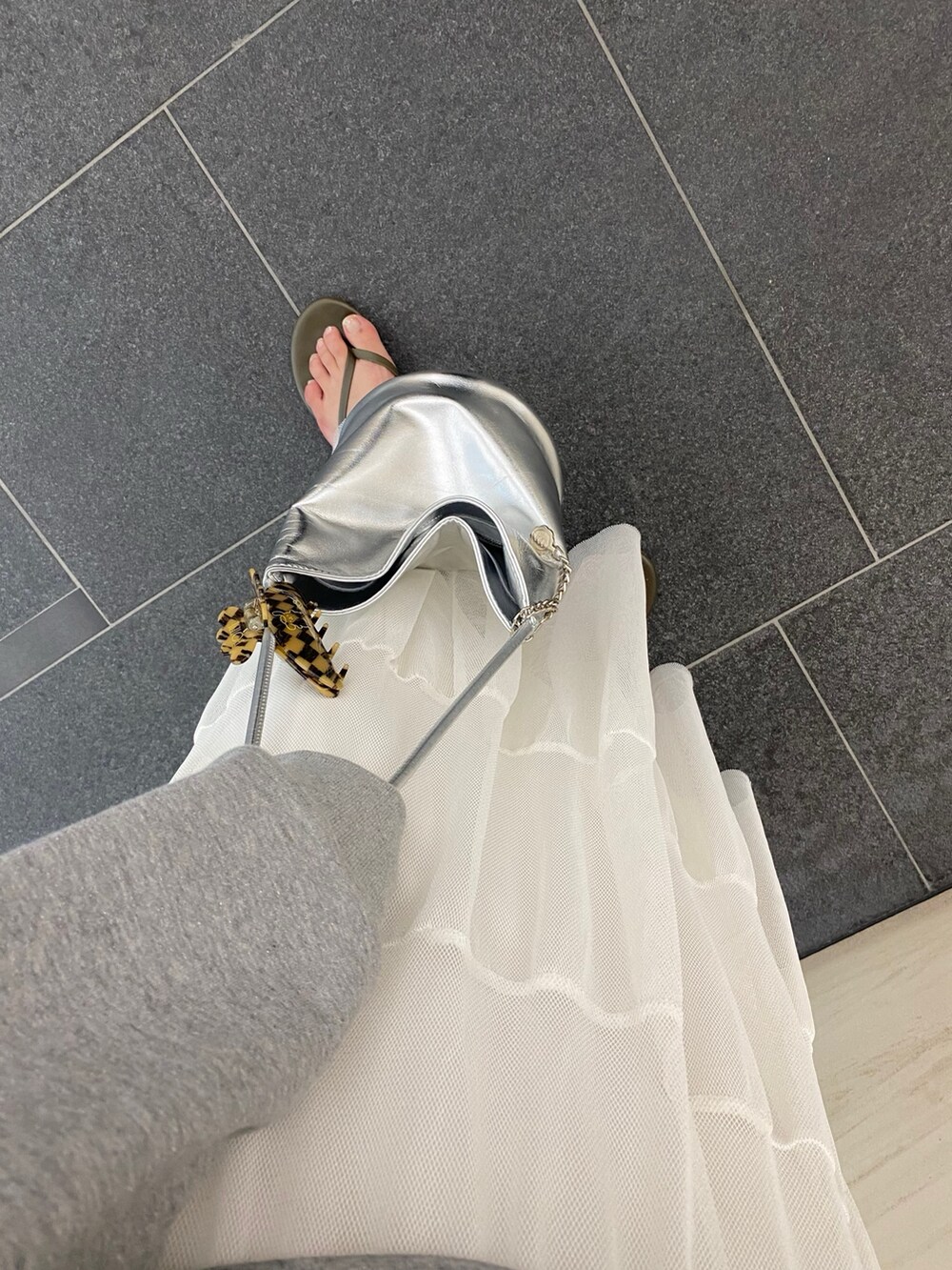 グレー系のTシャツ/カットソー、ホワイト系のスカート、シルバー系のショルダーバッグを着用したレディースの夏コーディネートの3枚目の写真