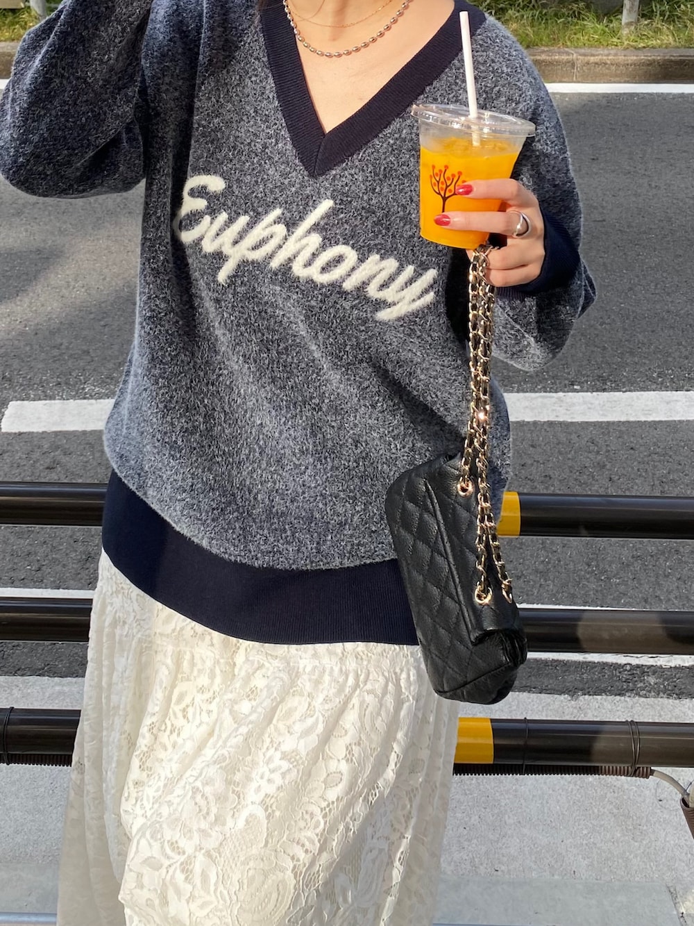 グレー系のムートンコート、ブルー系のニット/セーター、ホワイト系のスカートを着用したレディースの冬コーディネートの3枚目の写真