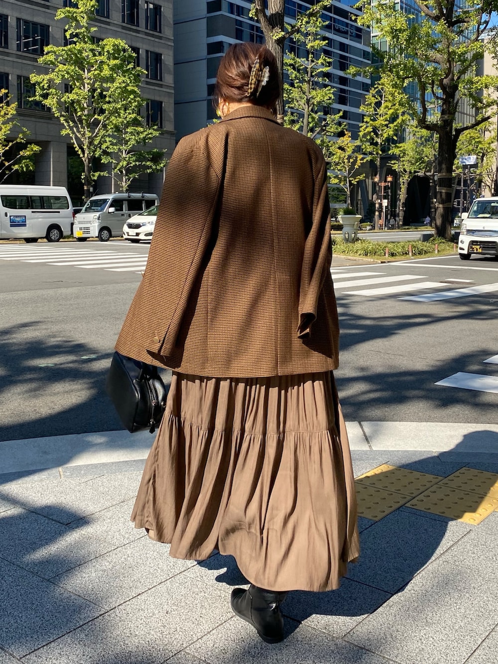 ブラウン系のベスト、ブラウン系のテーラードジャケット、ブラウン系のワンピースを着用したレディースの冬コーディネートの2枚目の写真