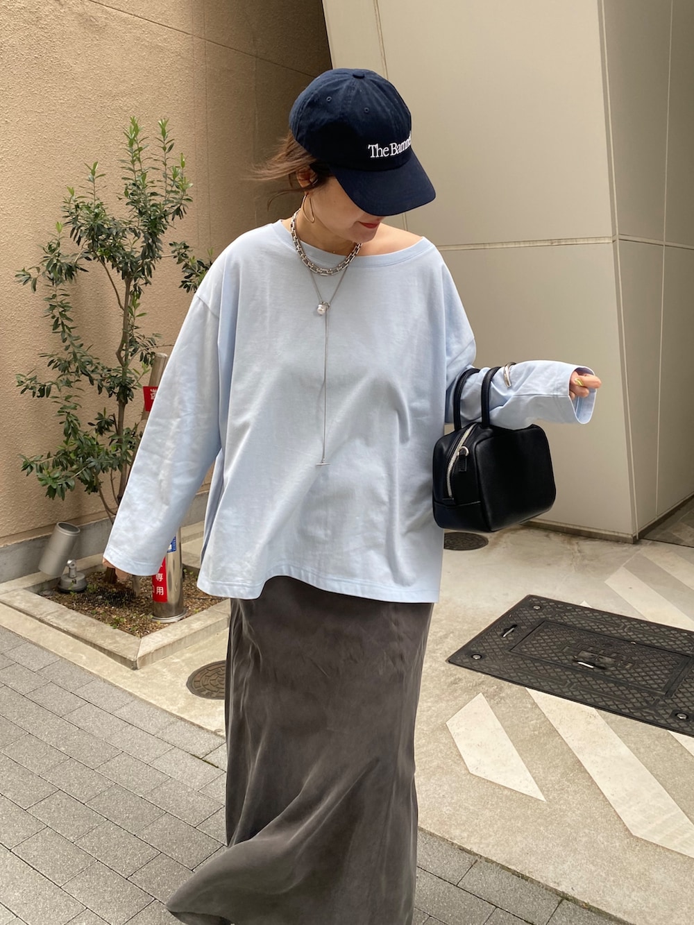 ブルー系のTシャツ/カットソー、ブラック系のスカート、ブラック系のショルダーバッグを着用したレディースの春コーディネートの3枚目の写真