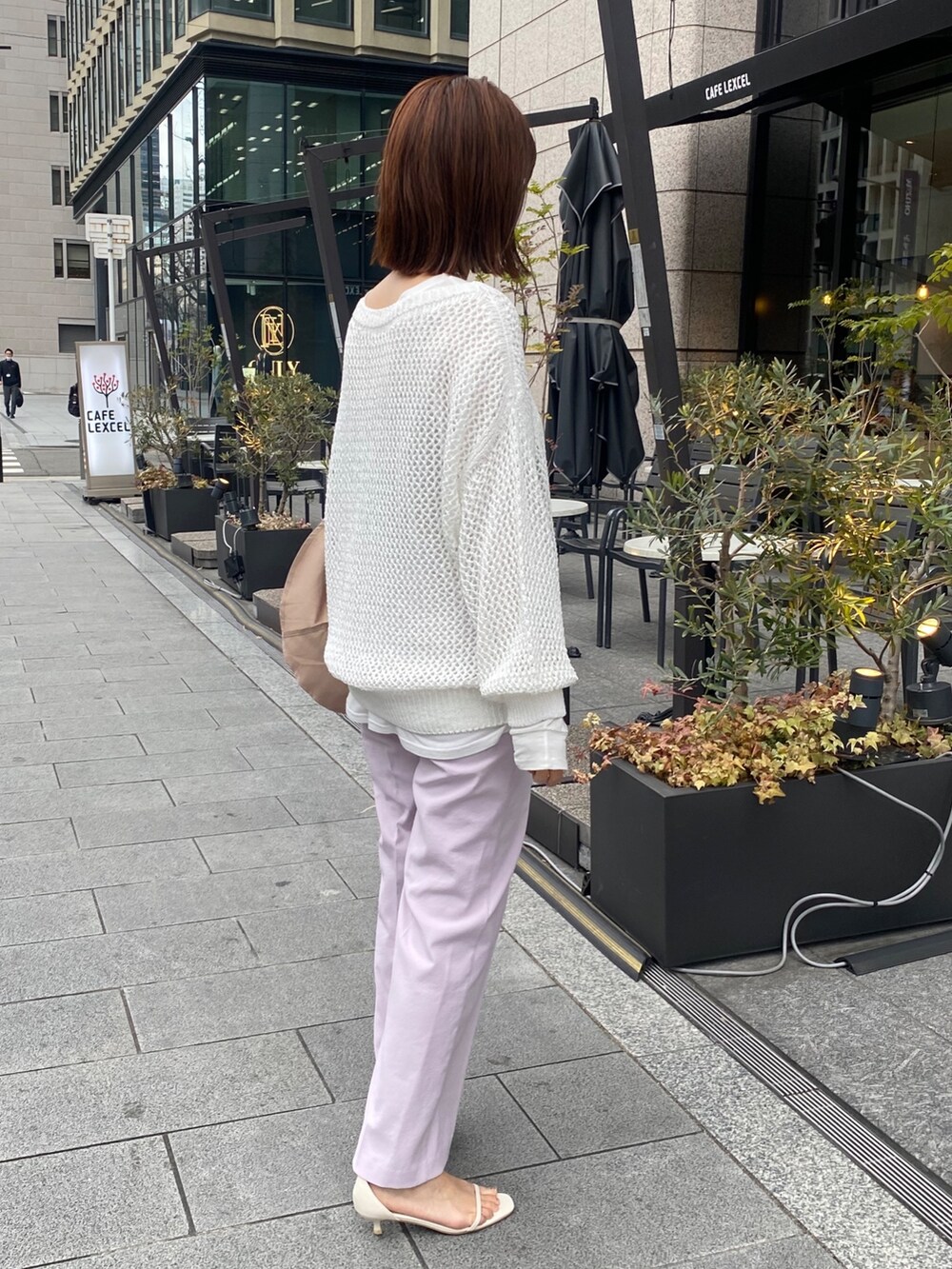 ホワイト系のニット/セーター、ホワイト系のTシャツ/カットソー、ピンク系のスラックスを着用したレディースの冬コーディネートの4枚目の写真