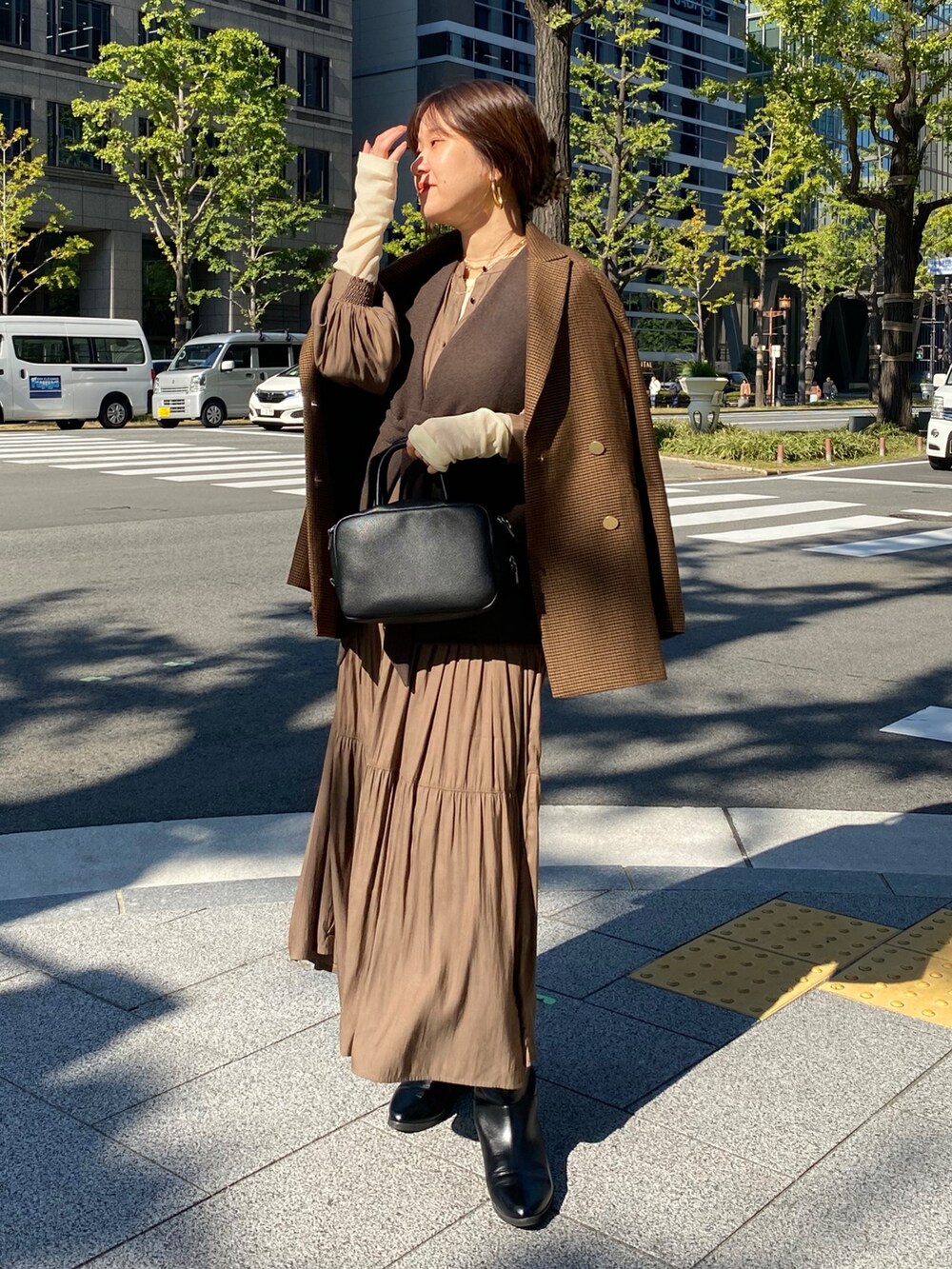 ブラウン系のベスト、ブラウン系のテーラードジャケット、ブラウン系のワンピースを着用したレディースの冬コーディネートの3枚目の写真