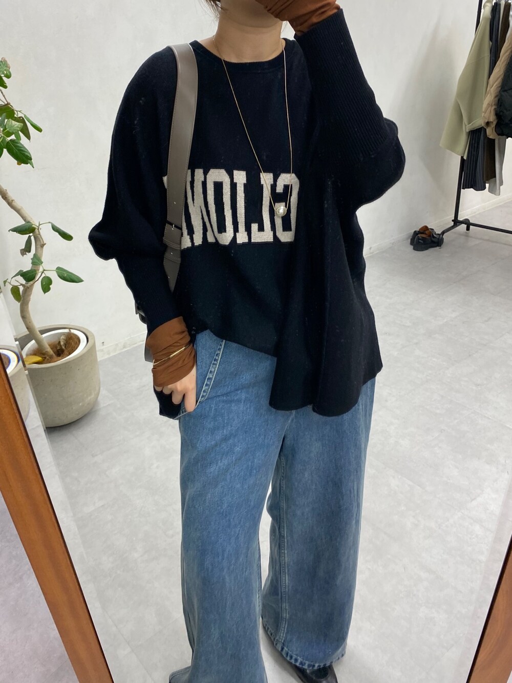 ブラック系のニット/セーター、ブルー系のデニムパンツ、ブラウン系のTシャツ/カットソーを着用したレディースの冬コーディネートの6枚目の写真