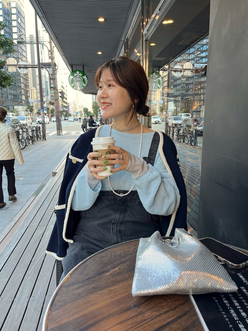 ブルー系のノーカラージャケット、ブラック系のサロペット/オーバーオール、ゴールド系のショルダーバッグを着用したレディースの冬コーディネートの3枚目の写真