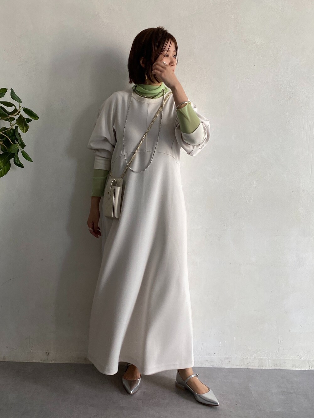グリーン系のTシャツ/カットソー、ホワイト系のショルダーバッグ、ホワイト系のワンピースを着用したレディースの冬コーディネートの3枚目の写真
