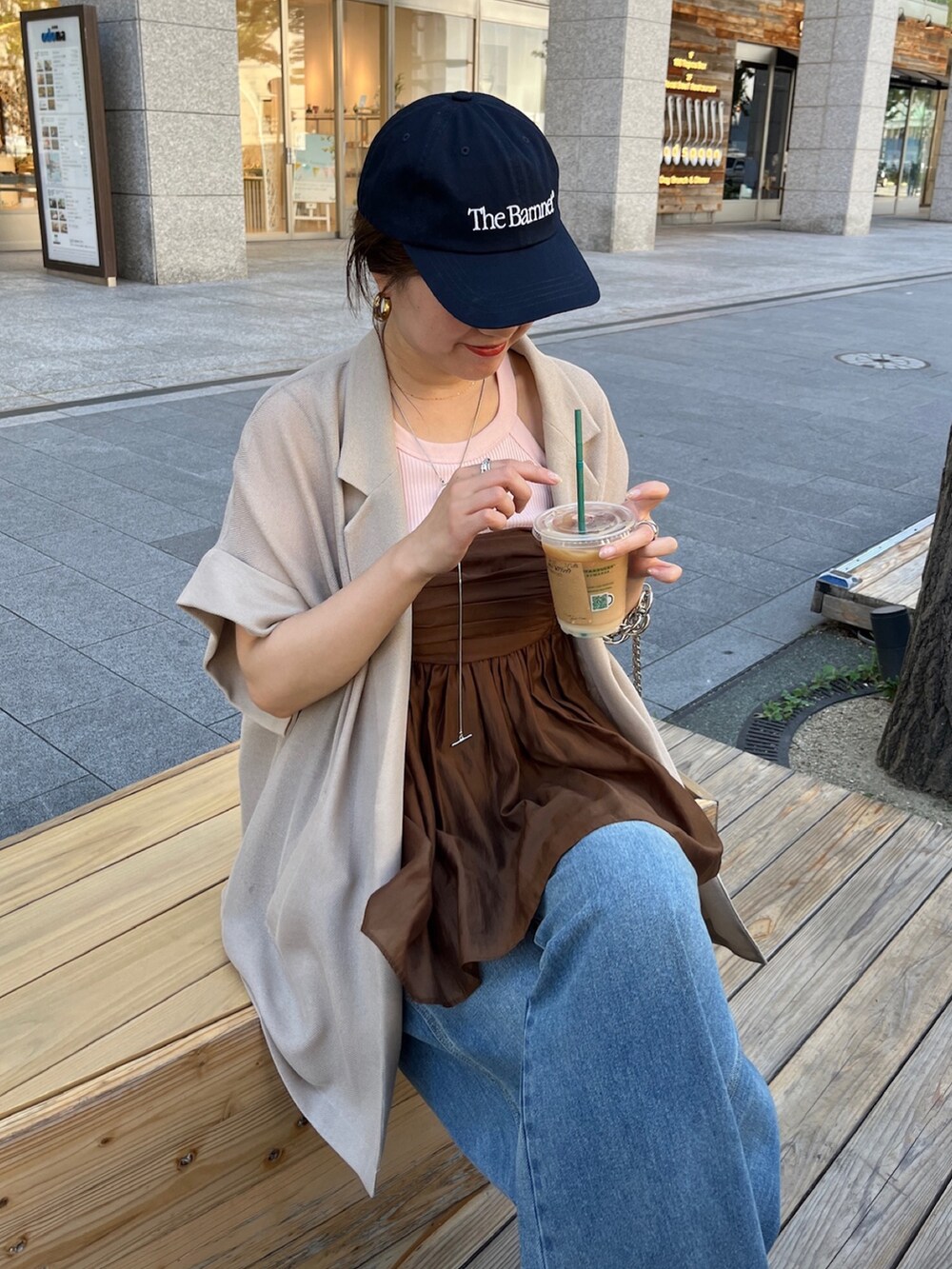 ベージュ系のテーラードジャケット、ブラウン系のキャミソール、ブルー系のデニムパンツを着用したレディースの夏コーディネートの7枚目の写真