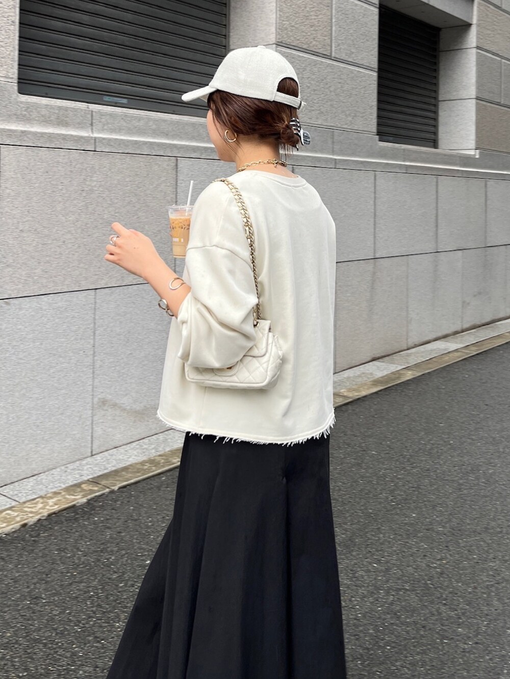 ベージュ系のスウェット、ブラック系のスカート、ホワイト系のショルダーバッグを着用したレディースの冬コーディネートの8枚目の写真