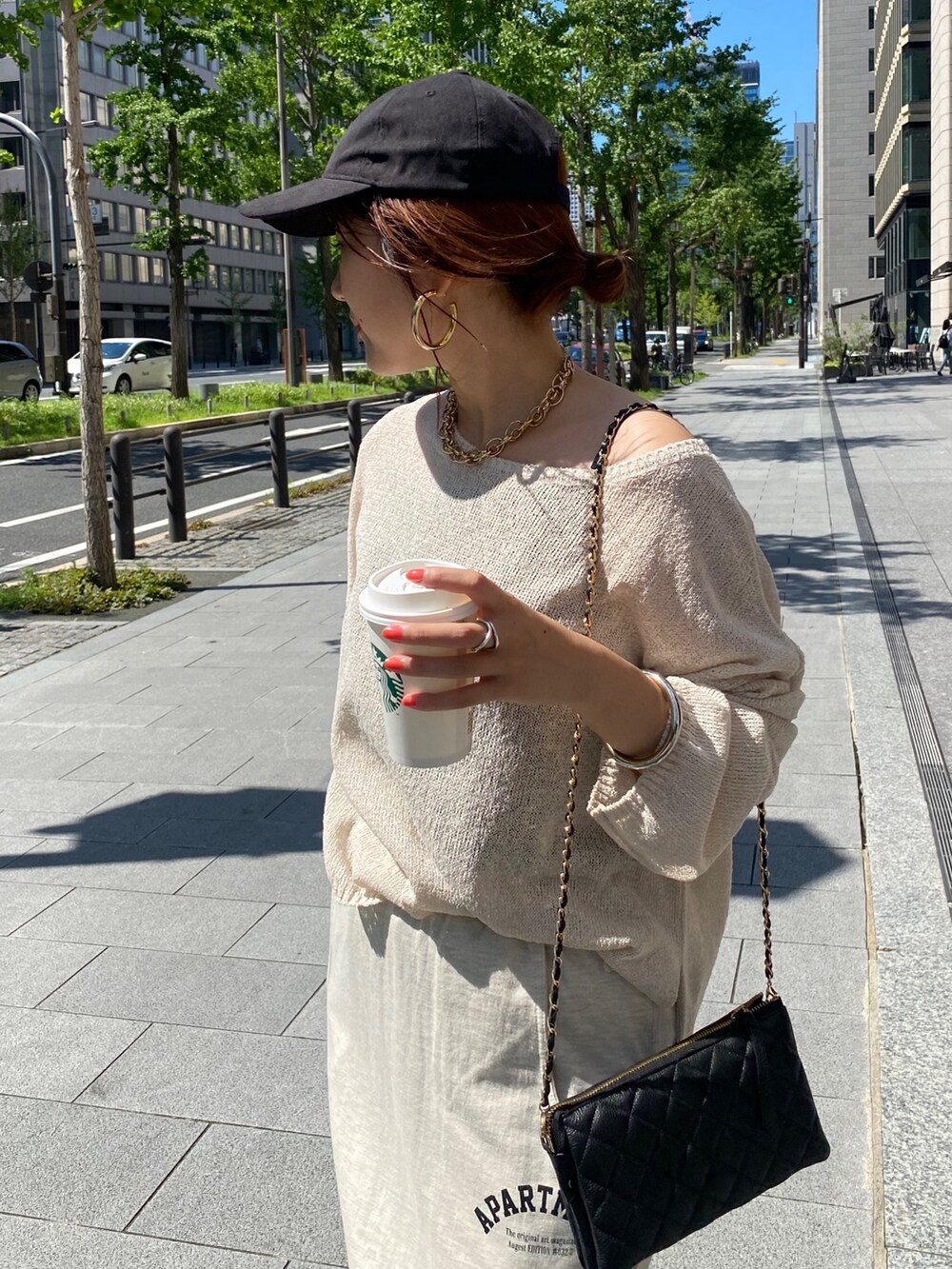 ベージュ系のニット/セーター、ベージュ系のスカート、ブラック系のショルダーバッグを着用したレディースの夏コーディネートの6枚目の写真