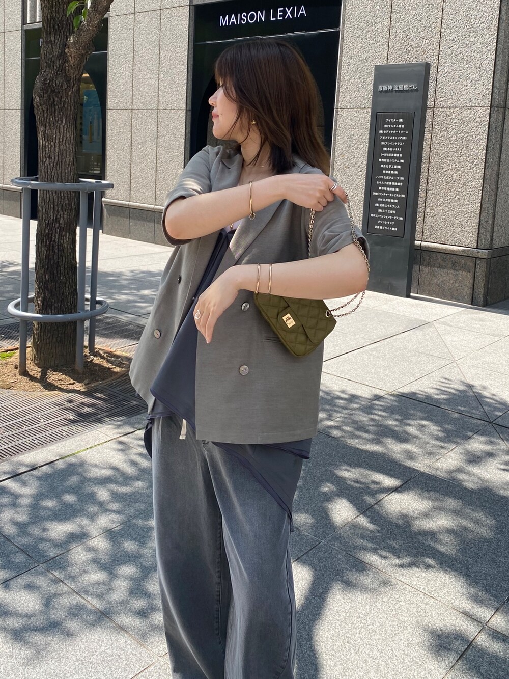 グレー系のテーラードジャケット、ブラック系のデニムパンツ、グレー系のシャツ/ブラウスを着用したレディースの夏コーディネートの4枚目の写真