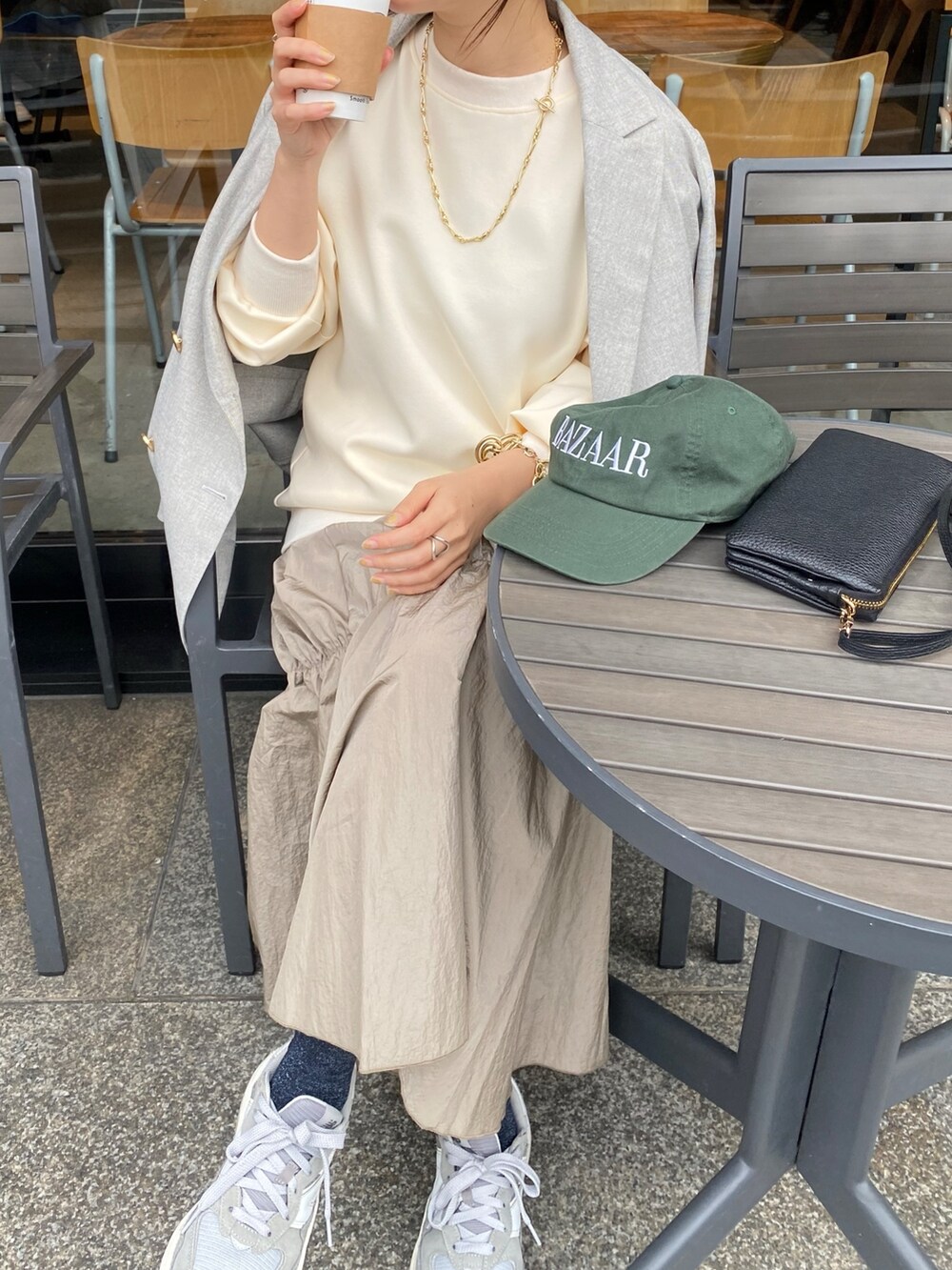 ホワイト系のワンピース、グレー系のテーラードジャケット、ゴールド系のブレスレットを着用したレディースの冬コーディネートの6枚目の写真