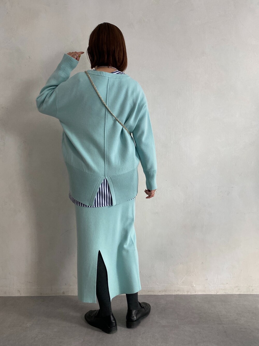 ブルー系のニット/セーター、ブルー系のシャツ/ブラウス、ブルー系のスカートを着用したレディースの冬コーディネートの4枚目の写真