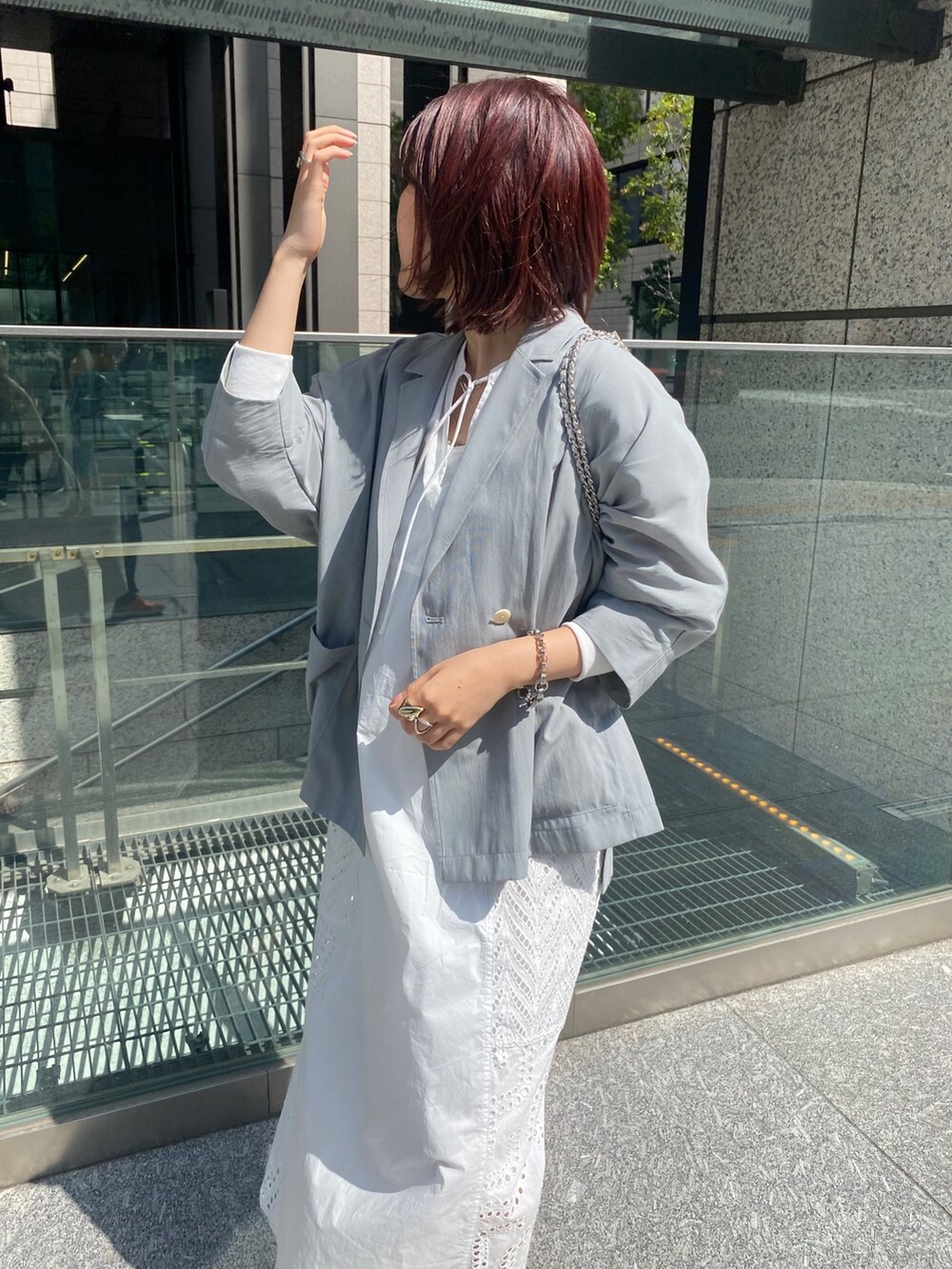 グレー系のテーラードジャケット、ホワイト系のワンピース/ドレス、シルバー系のショルダーバッグを着用したレディースの春コーディネートの4枚目の写真