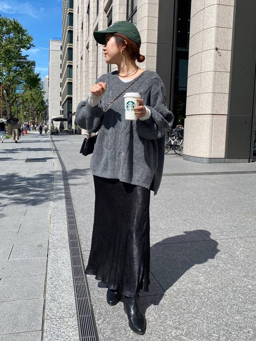 グレー系のニット/セーター、ブラック系のスカートを着用したレディースの秋コーディネートの5枚目の写真