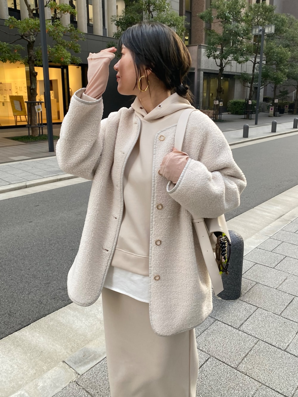 ホワイト系のセットアップ、ホワイト系のその他アウター、ホワイト系のショルダーバッグを着用したレディースの冬コーディネートの3枚目の写真