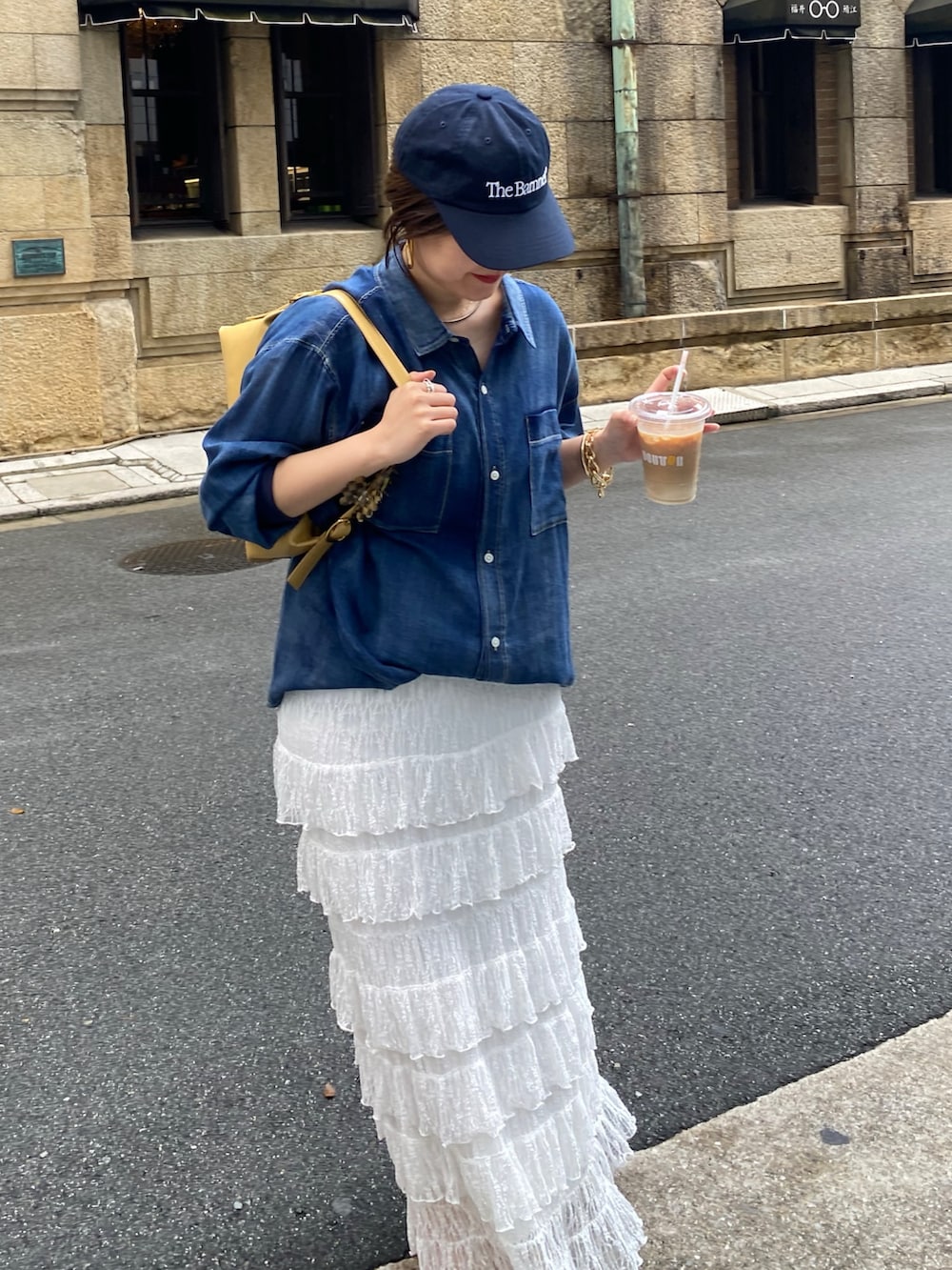 ブルー系のシャツ/ブラウス、ホワイト系のスカート、ゴールド系のネックレスを着用したレディースの春コーディネートの2枚目の写真