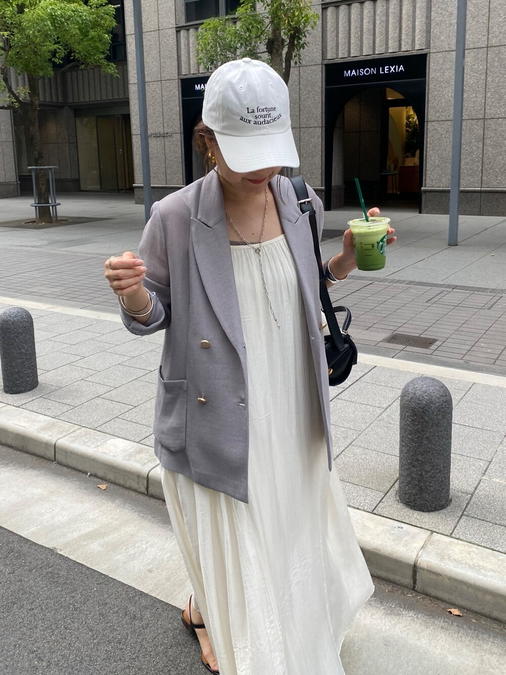 ブルー系のテーラードジャケット、ホワイト系のワンピース、ブラウン系のショルダーバッグを着用したレディースの春コーディネートの9枚目の写真