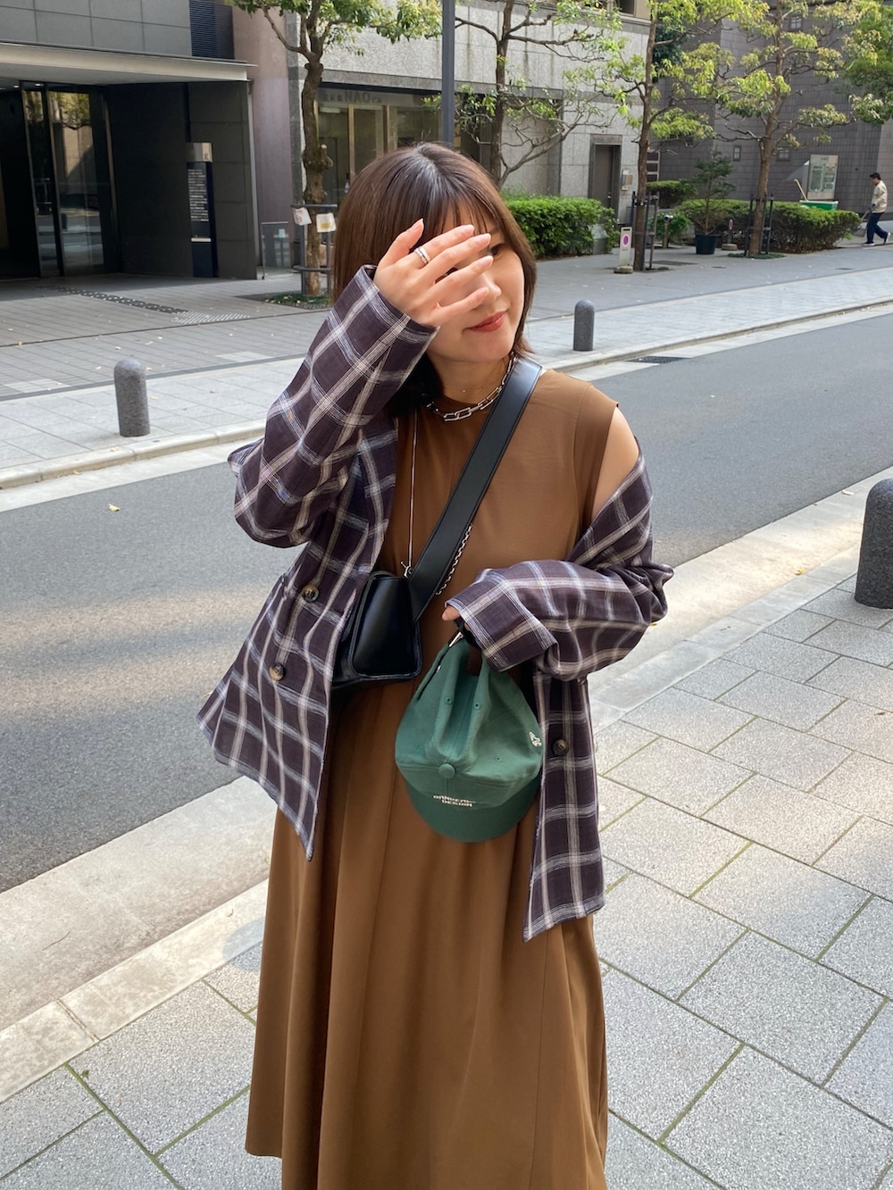 グリーン系のワンピース、ホワイト系のテーラードジャケット、ホワイト系のその他パンツを着用したレディースの春コーディネートの3枚目の写真