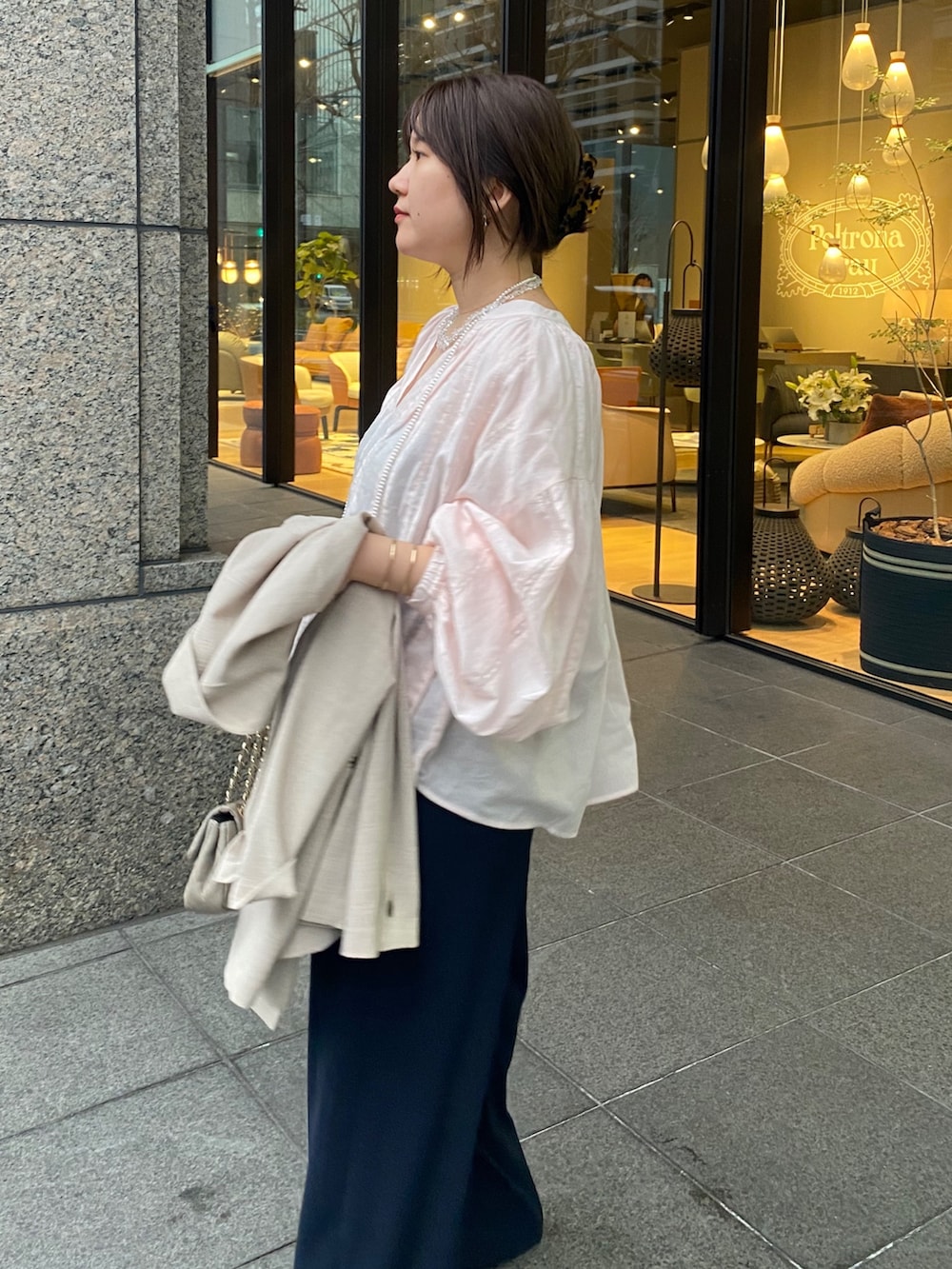 ピンク系のシャツ/ブラウス、ブルー系のスラックス、その他のネックレスを着用したレディースの春コーディネートの6枚目の写真