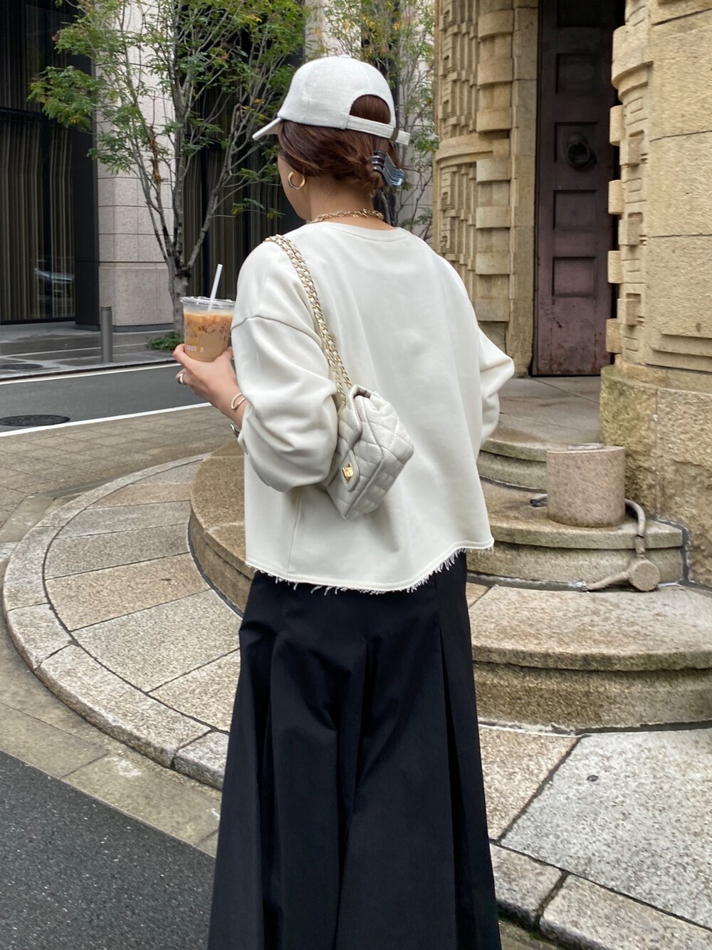 ベージュ系のスウェット、ブラック系のスカート、ホワイト系のショルダーバッグを着用したレディースの冬コーディネートの6枚目の写真