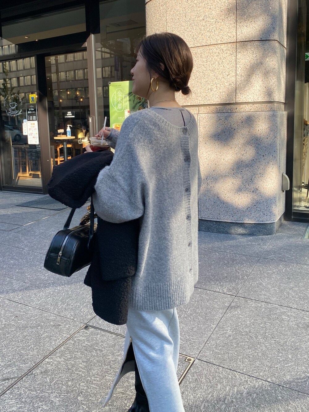 ホワイト系のTシャツ/カットソー、グレー系のニット/セーター、グレー系のスカートを着用したレディースの冬コーディネートの5枚目の写真