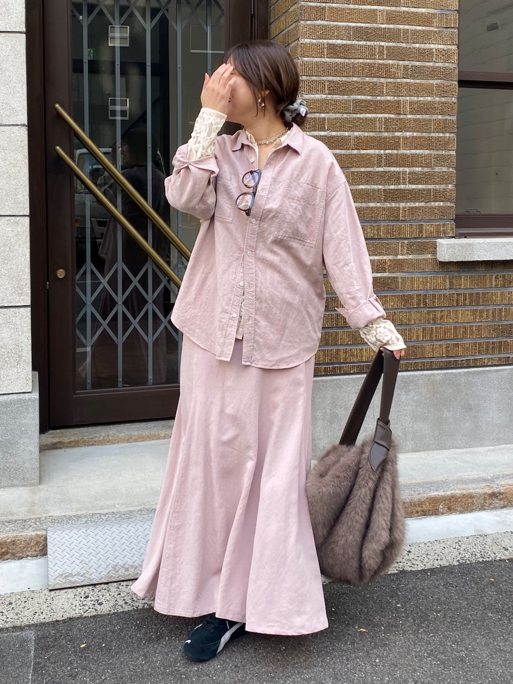 ピンク系のシャツ/ブラウス、ピンク系のスカート、ブラウン系のショルダーバッグを着用したレディースの冬コーディネートの5枚目の写真