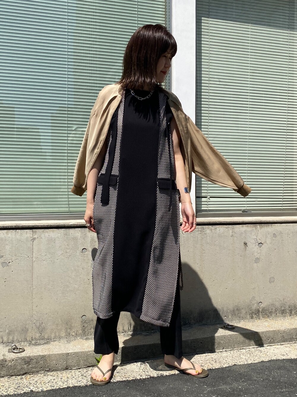 ベージュ系のブルゾン、ブラック系のワンピースを着用したレディースの夏コーディネートの5枚目の写真