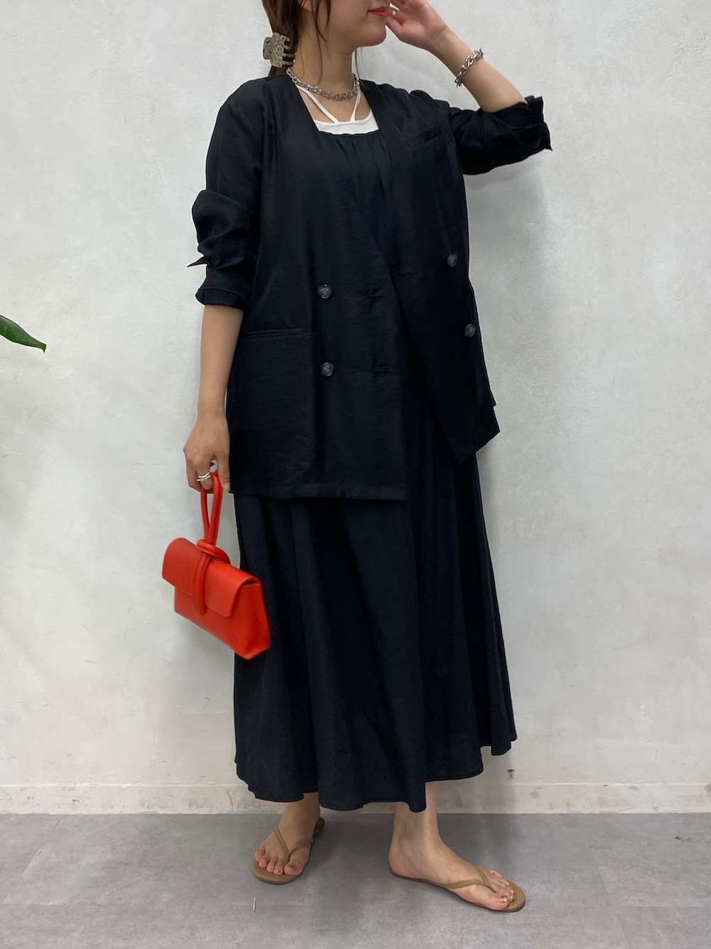 ブラック系のブルゾン、ブラック系のワンピース、ホワイト系のタンクトップを着用したレディースの夏コーディネートの3枚目の写真