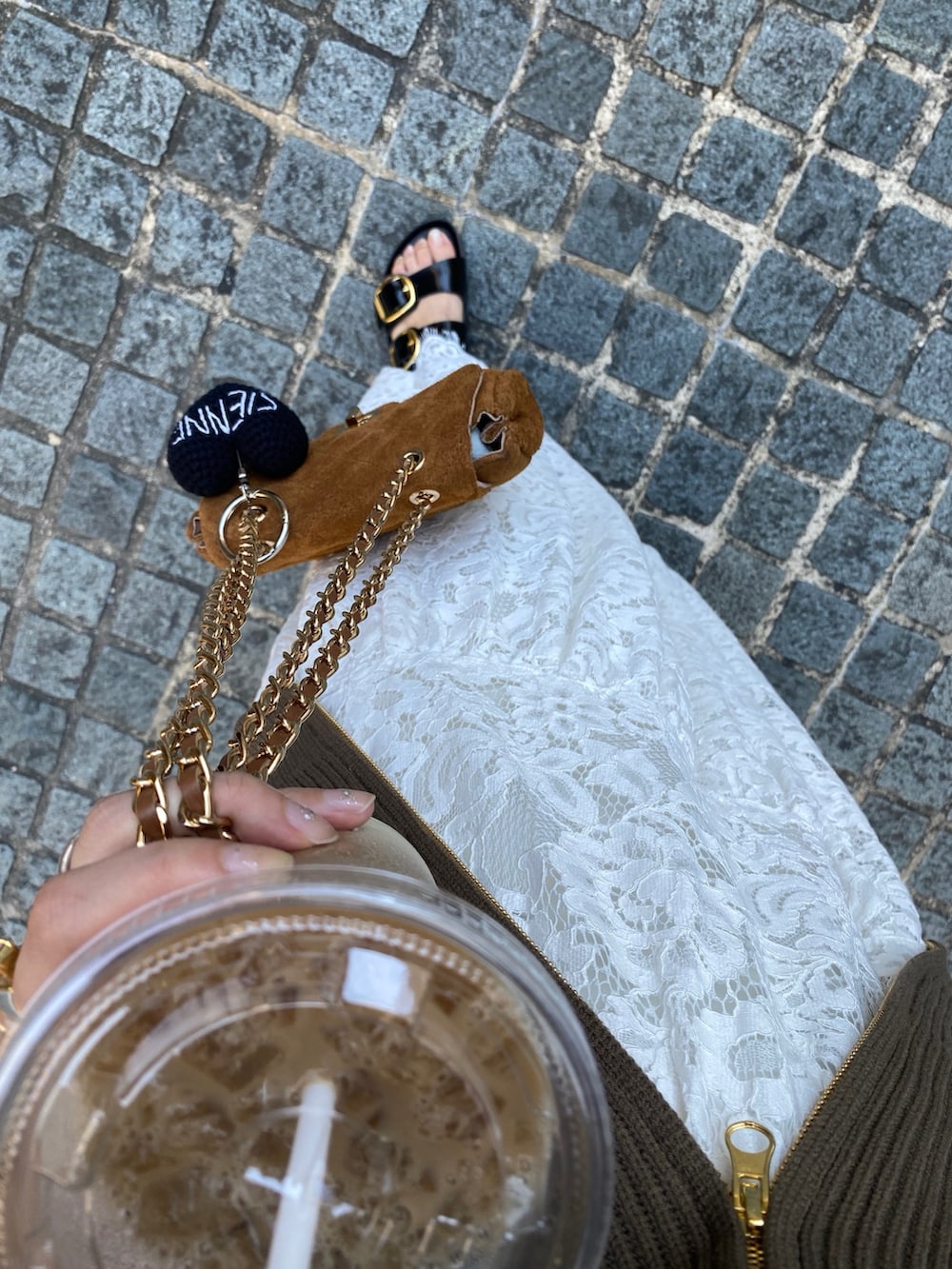 ブラウン系のニット/セーター、イエロー系のショルダーバッグ、ホワイト系のスカートを着用したレディースの秋コーディネートの6枚目の写真