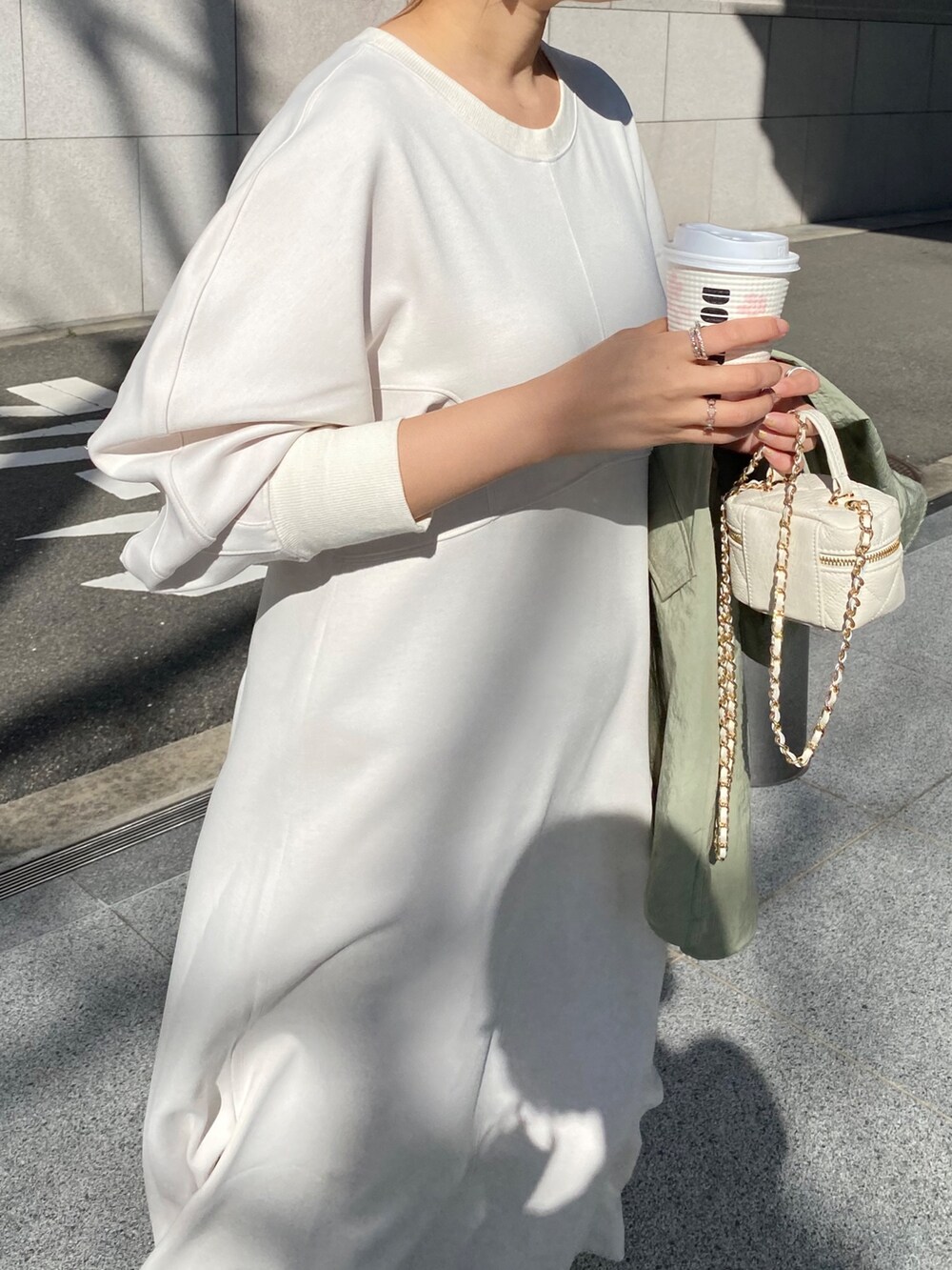 ホワイト系のワンピース、ブラック系のショルダーバッグを着用したレディースの春コーディネートの9枚目の写真