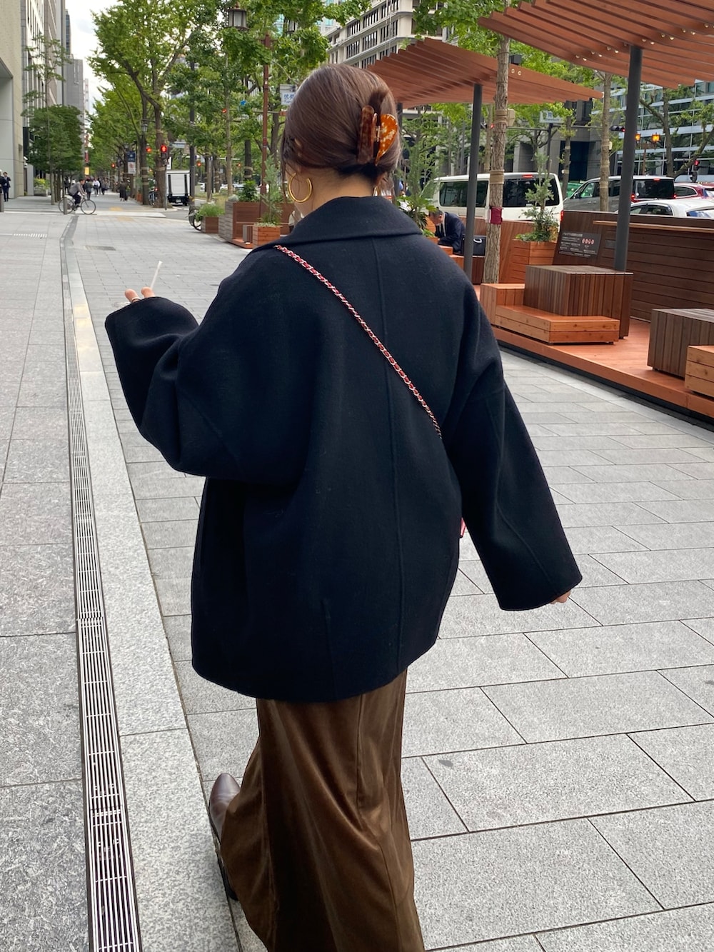 ブルー系のスウェット、ブラウン系のブーツ、レッド系のショルダーバッグを着用したレディースの秋コーディネートの9枚目の写真